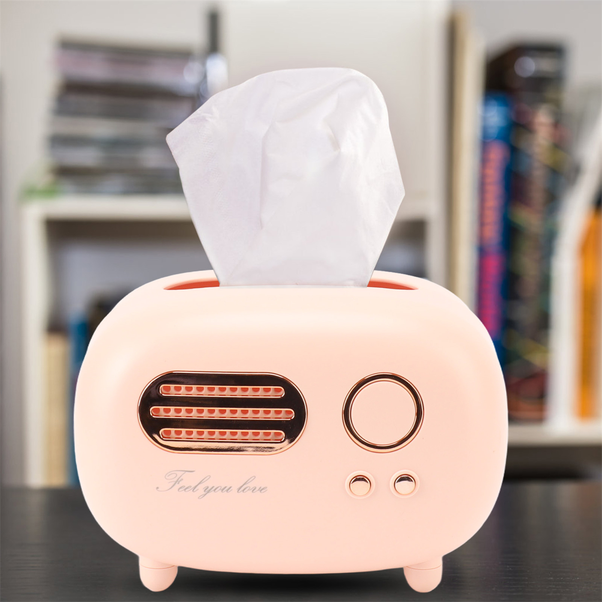 Eine rosa Taschentuchbox in Form eines Retro-Radios, mit der Aufschrift 'Feel you love'. Weißer Hintergrund.