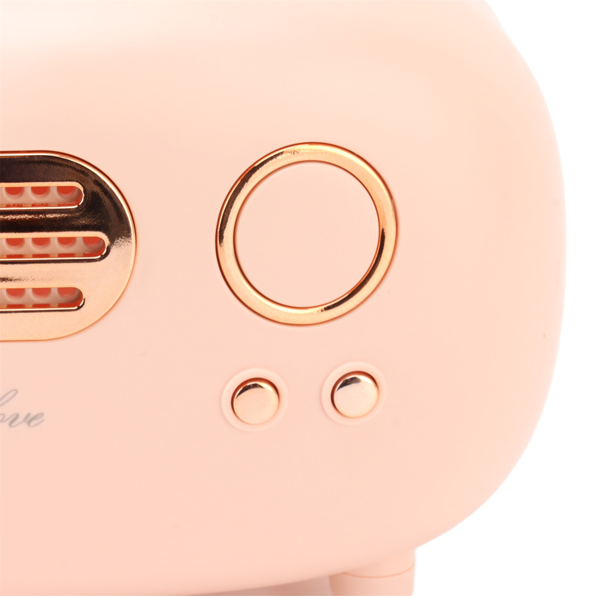 Nahaufnahme eines rosa Geräts mit zwei Knöpfen und einem goldenen kreisförmigen Akzent.