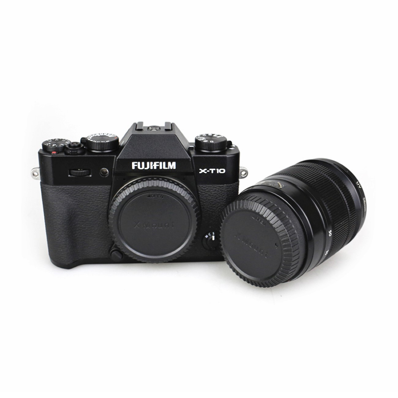 Schwarze Fujifilm X-T10 Kamera mit Objektiv. Kamera steht auf weißer Oberfläche. Objektiv ist angebracht.