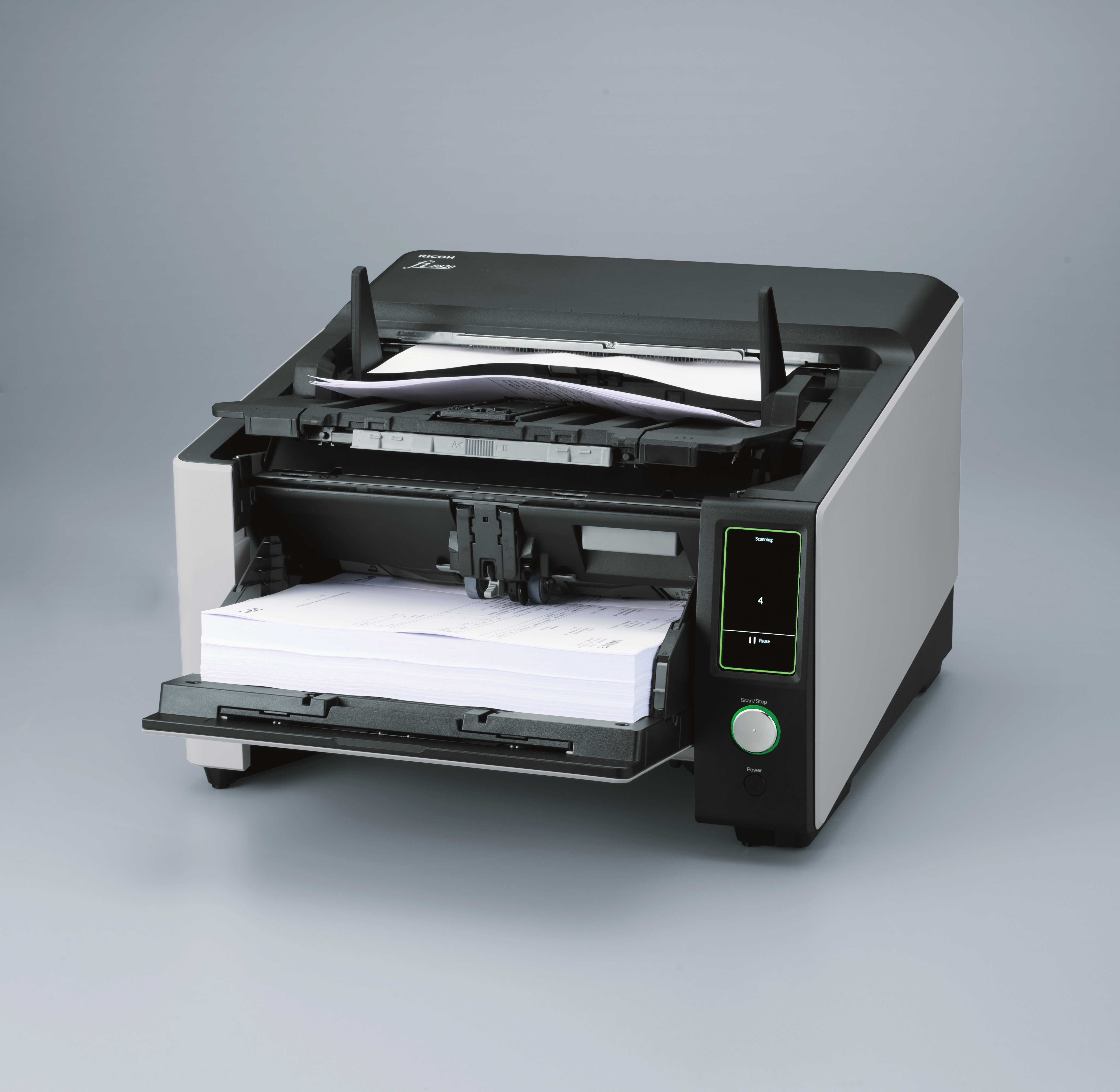 Zwarte en grijze scanner met papier erin. Open met papier in de lade.