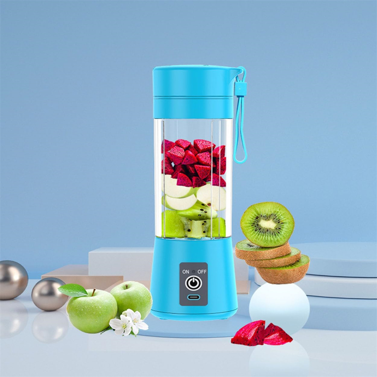 Blauer Mixer mit Früchten darin, und Kiwis und Äpfel darum herum. Blauer und weißer Hintergrund.