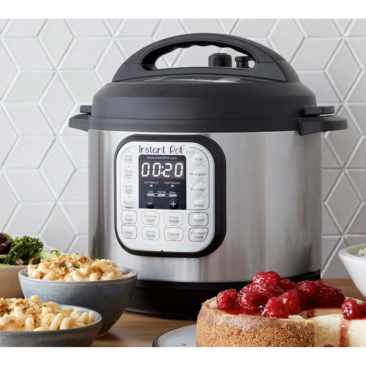 Un Instant Pot su un tavolo con altri alimenti in ciotole. È argento e nero.