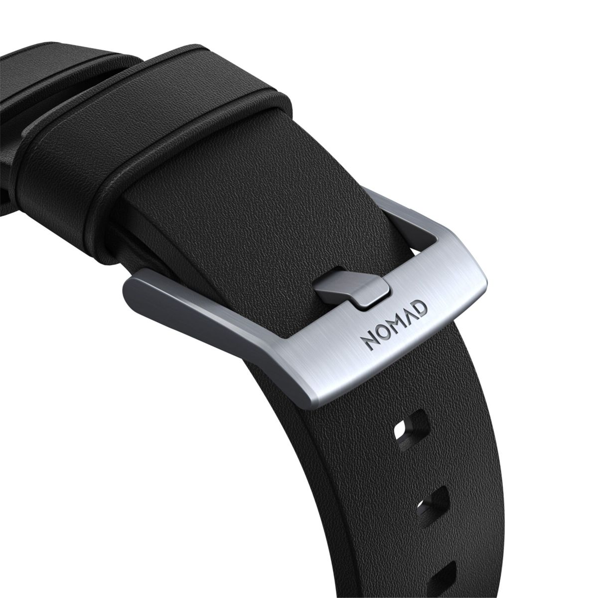 Nahaufnahme eines schwarzen Leder-Uhrenarmbands mit einer silbernen Schnalle. Die Schnalle hat die Gravur "NOMAD".