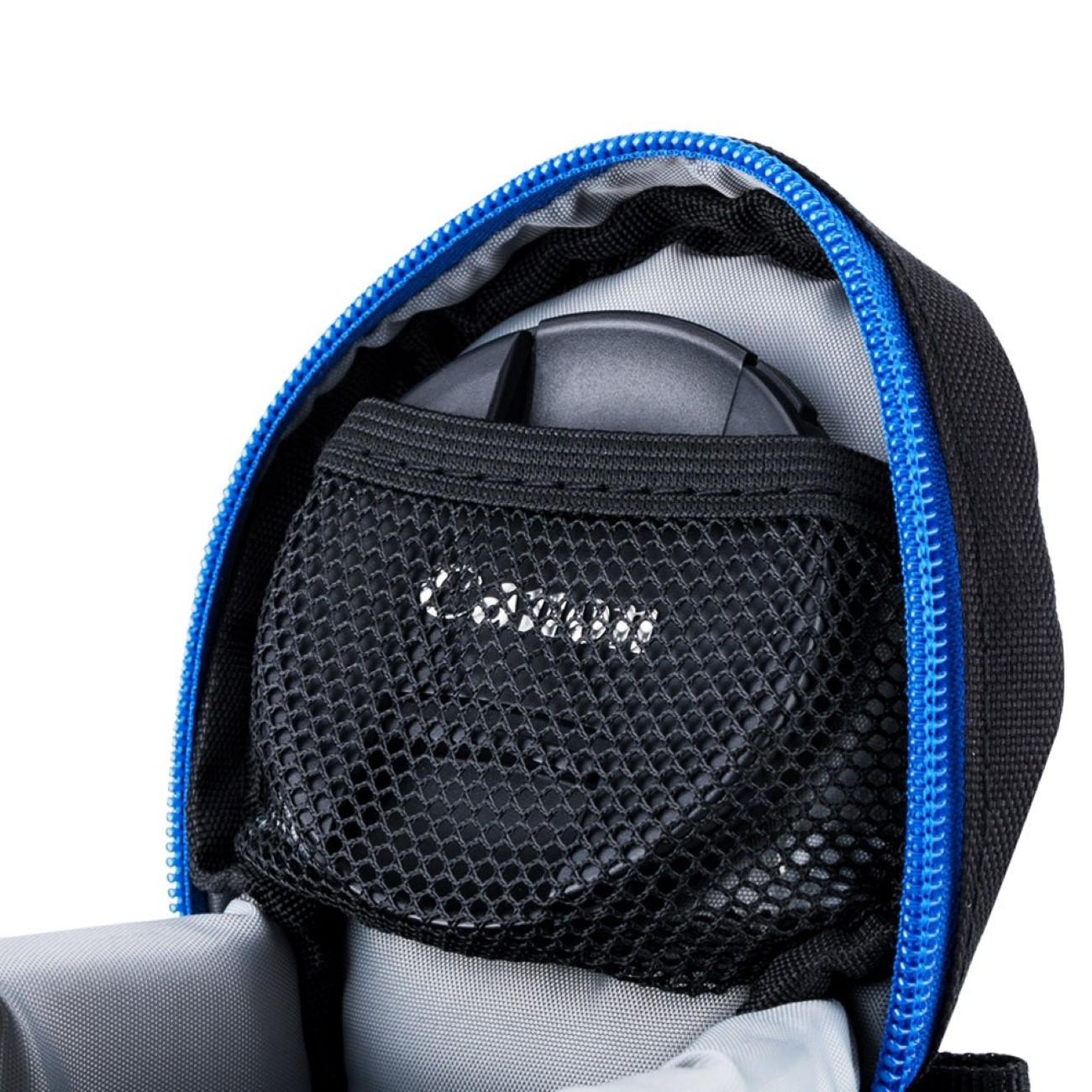 Ein Canon-Kameraobjektiv in einer schwarzen Netztasche in einer blau umrandeten Kameratasche.
