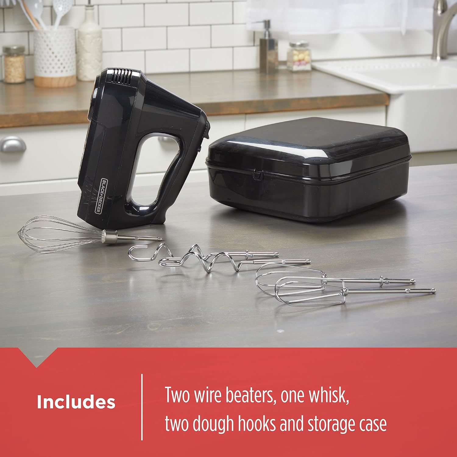 Ein schwarzer Handmixer mit Aufsätzen und Aufbewahrungskoffer auf einer Holzoberfläche, mit Text darunter.