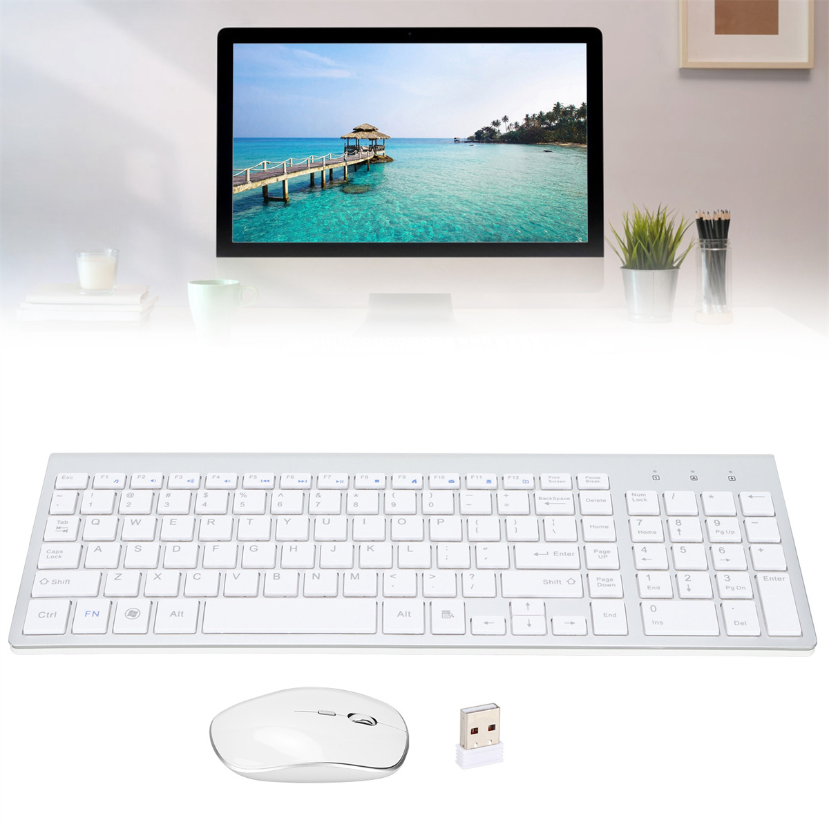 Weiße Tastatur, Maus und USB-Empfänger. Ein Computermonitor zeigt eine Strandszene im Hintergrund.
