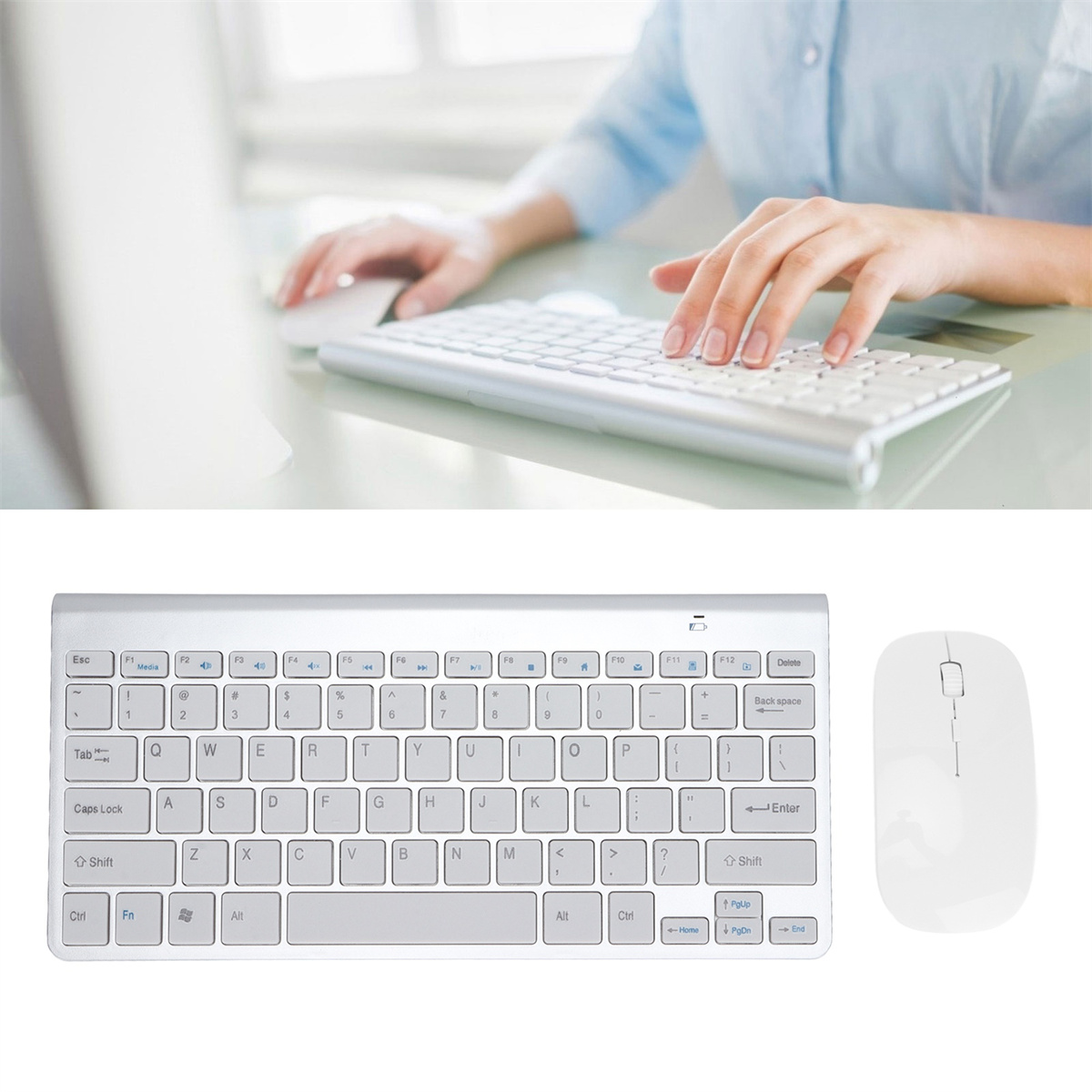 Eine Person, die auf einer weißen Tastatur mit einer weißen Maus auf einem Schreibtisch tippt.