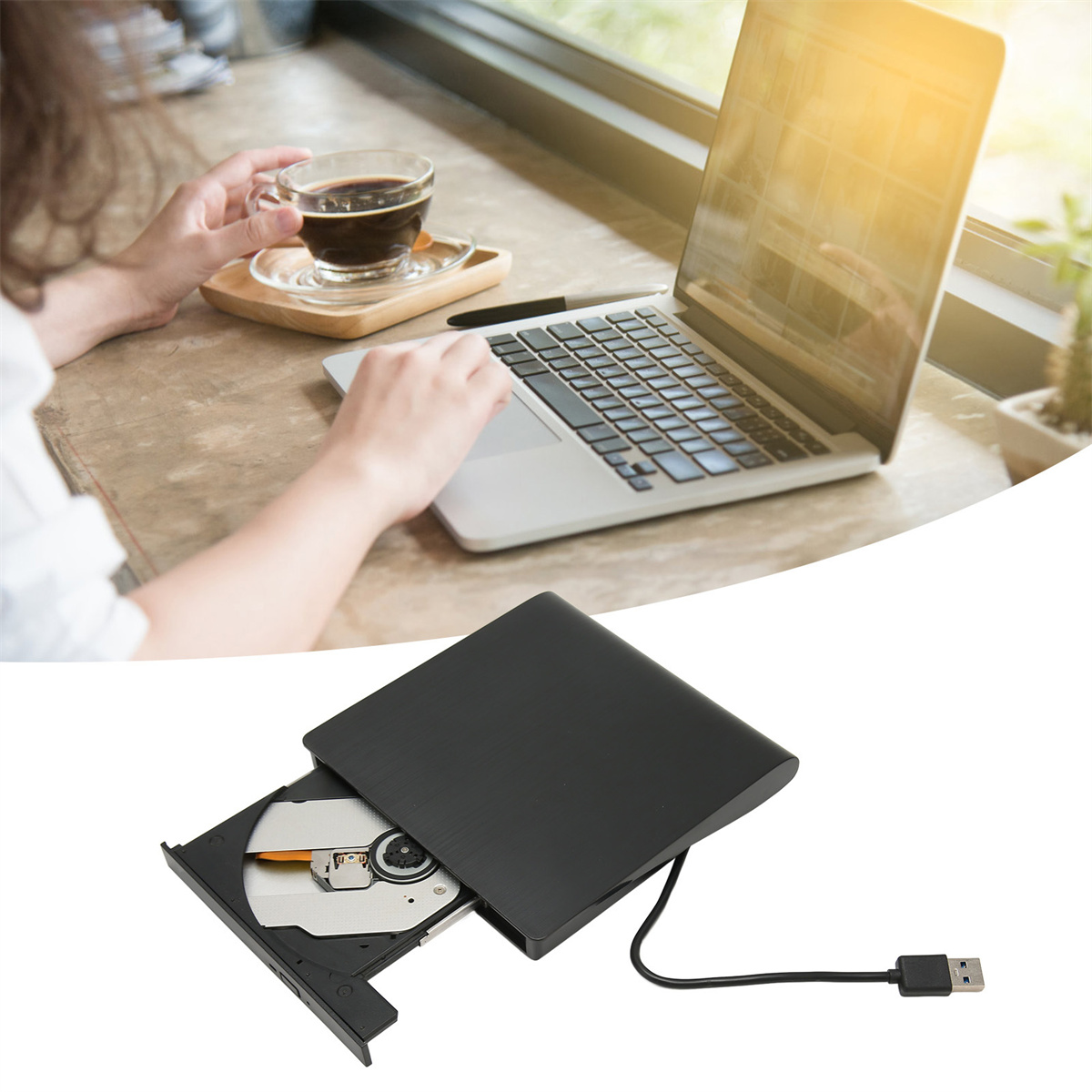 Laptop geöffnet auf einem Holztisch, Person hält Kaffeetasse. Ein DVD-Laufwerk ist ebenfalls sichtbar.