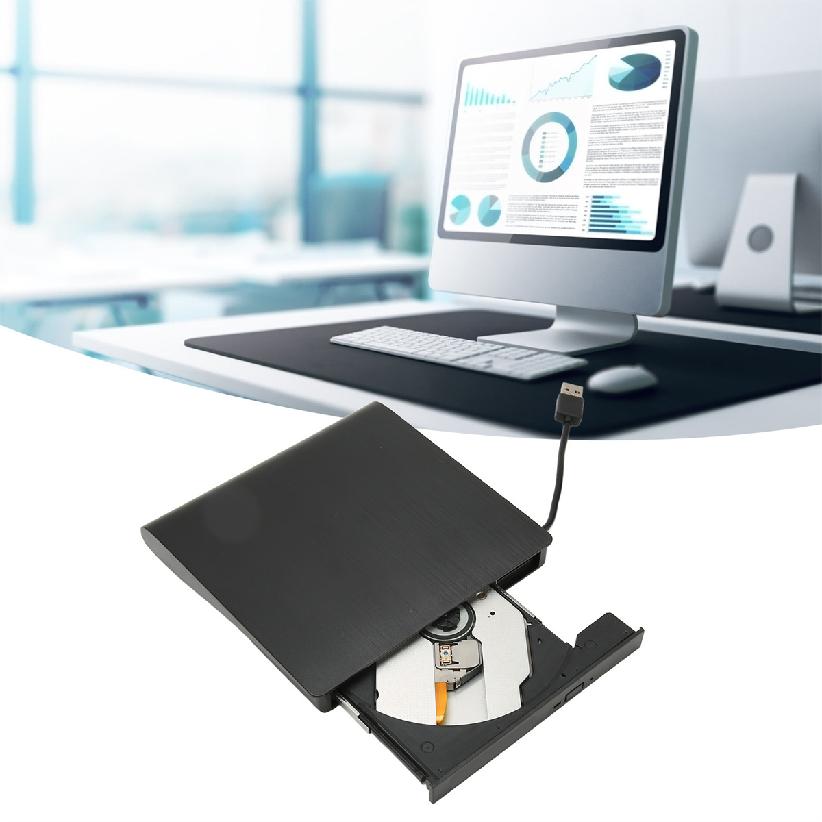 Externes CD-Laufwerk mit offenem Fach und Computerbildschirm im Hintergrund.