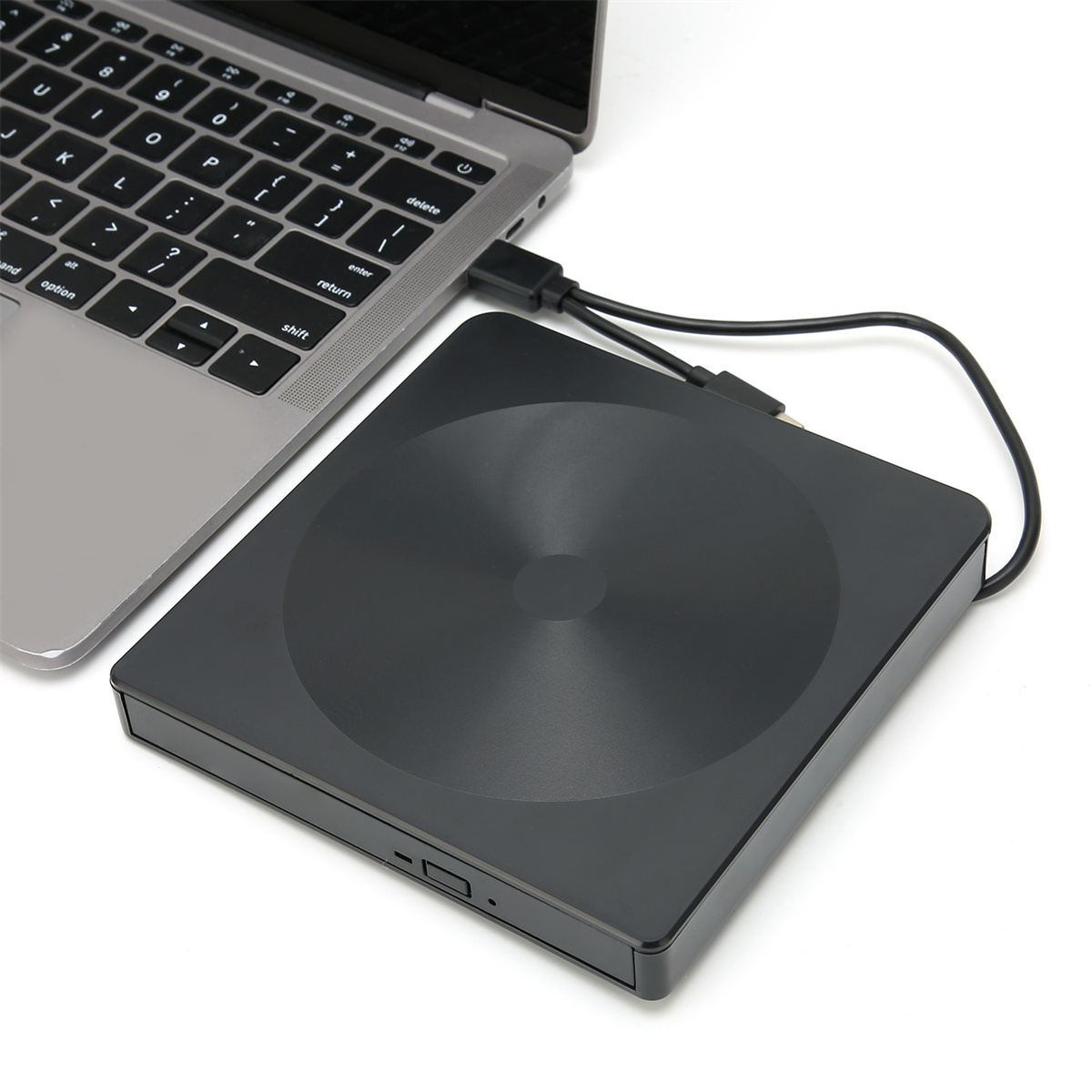 Schwarzes externes CD/DVD-Laufwerk an Laptop angeschlossen. Laptop ist silber.