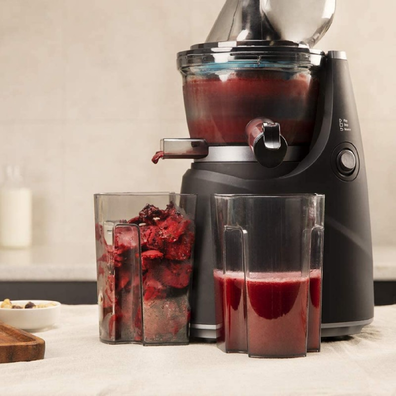 Estrattore di succo con due contenitori, uno con succo, l'altro con polpa, in una cucina.