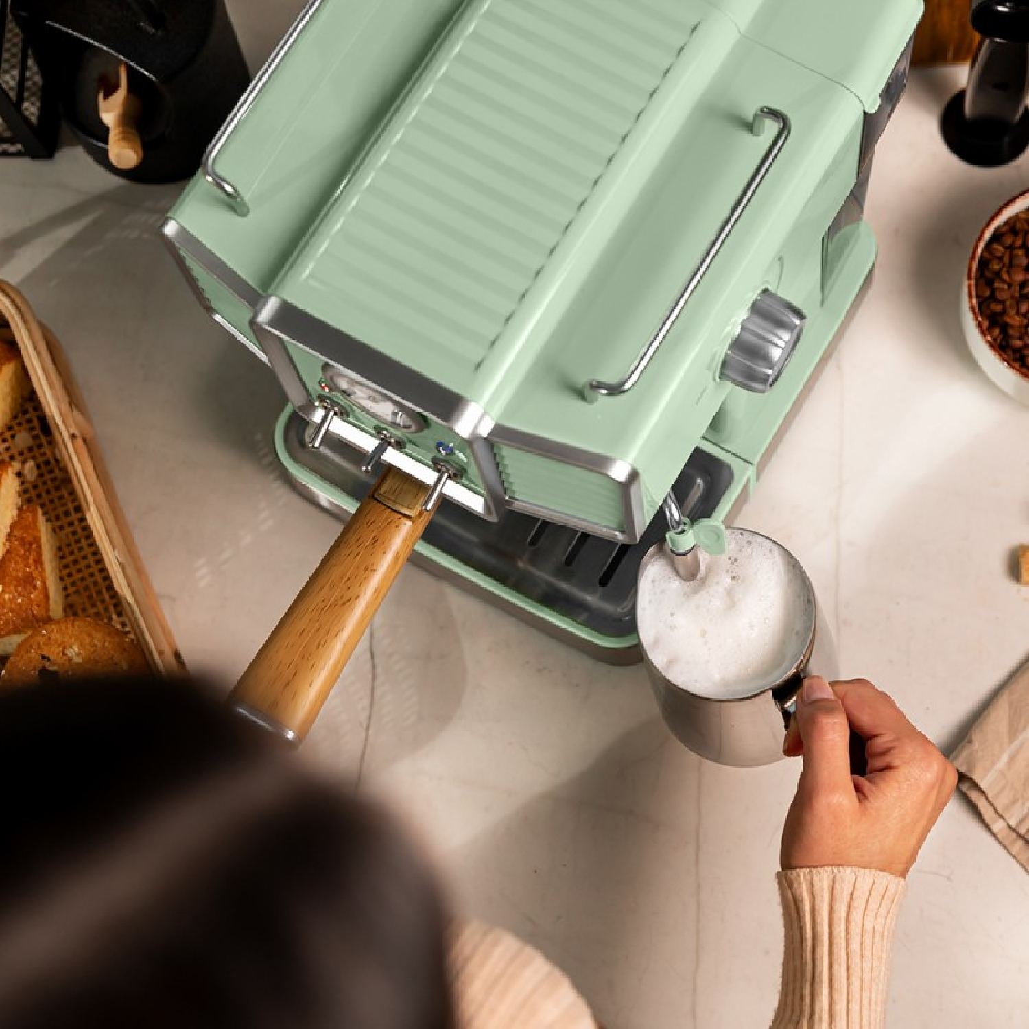 Una macchina per l'espresso verde menta con manico in legno.