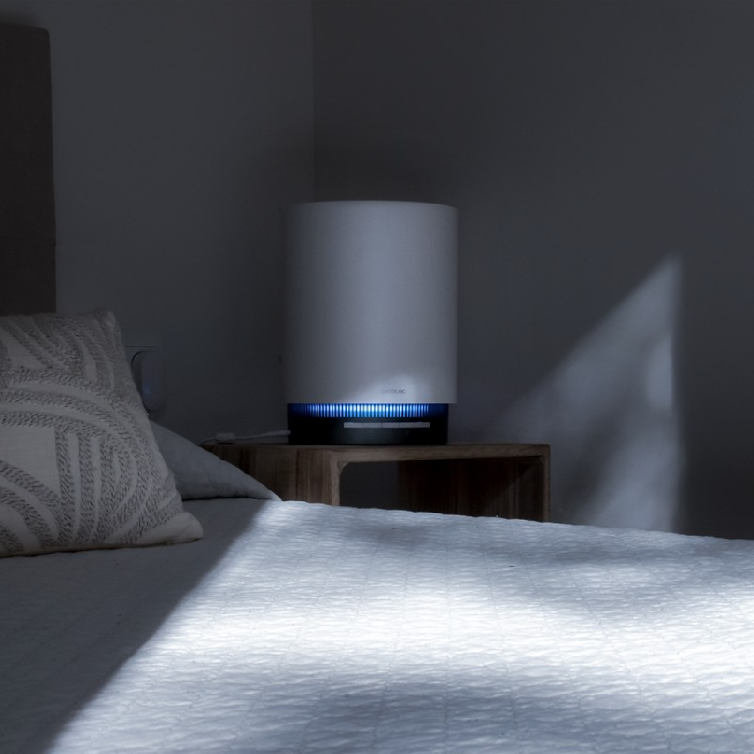 Una lampada da comodino bianca emette luce blu in una camera da letto.