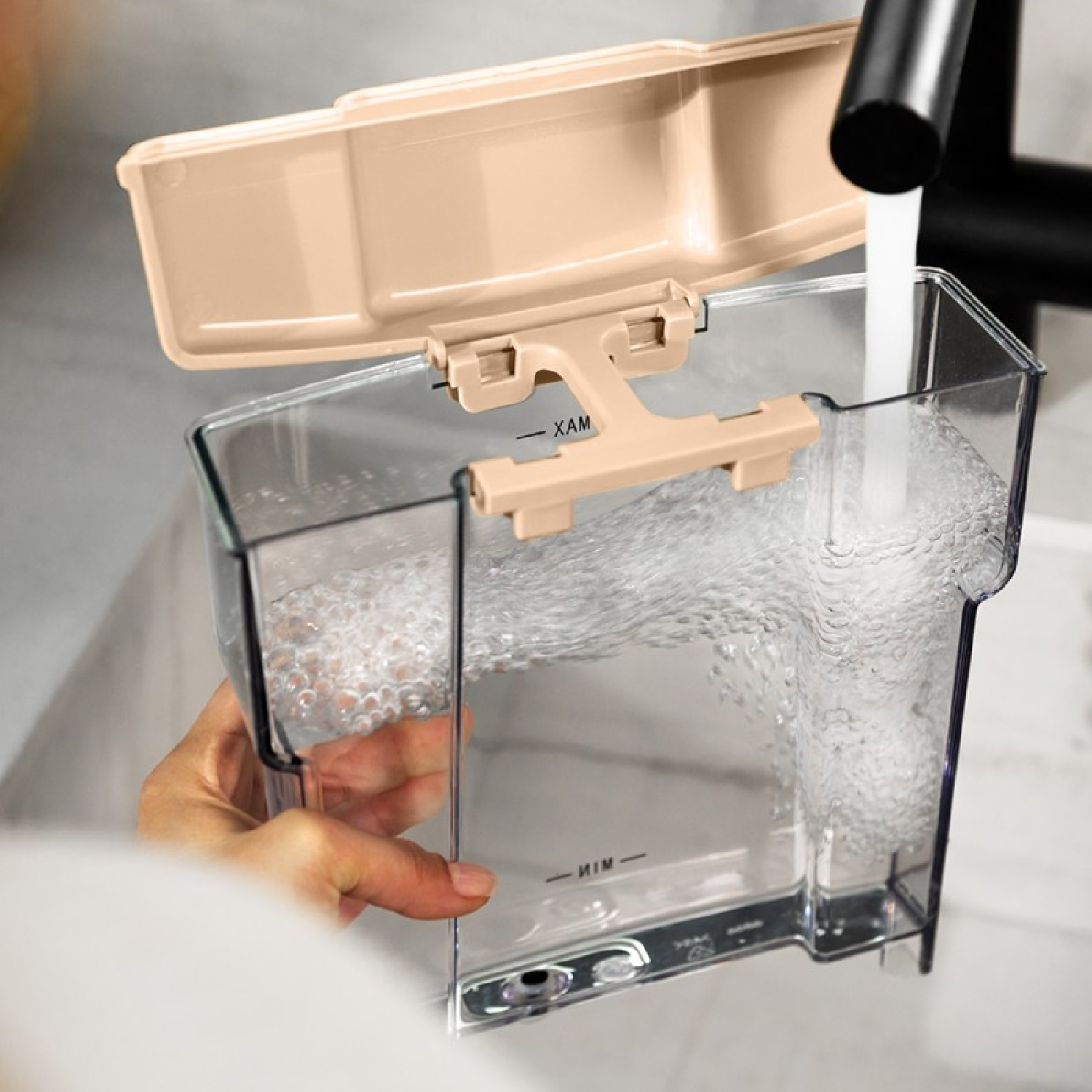 Un contenitore viene riempito d'acqua. Il contenitore ha un coperchio beige. L'acqua è limpida.