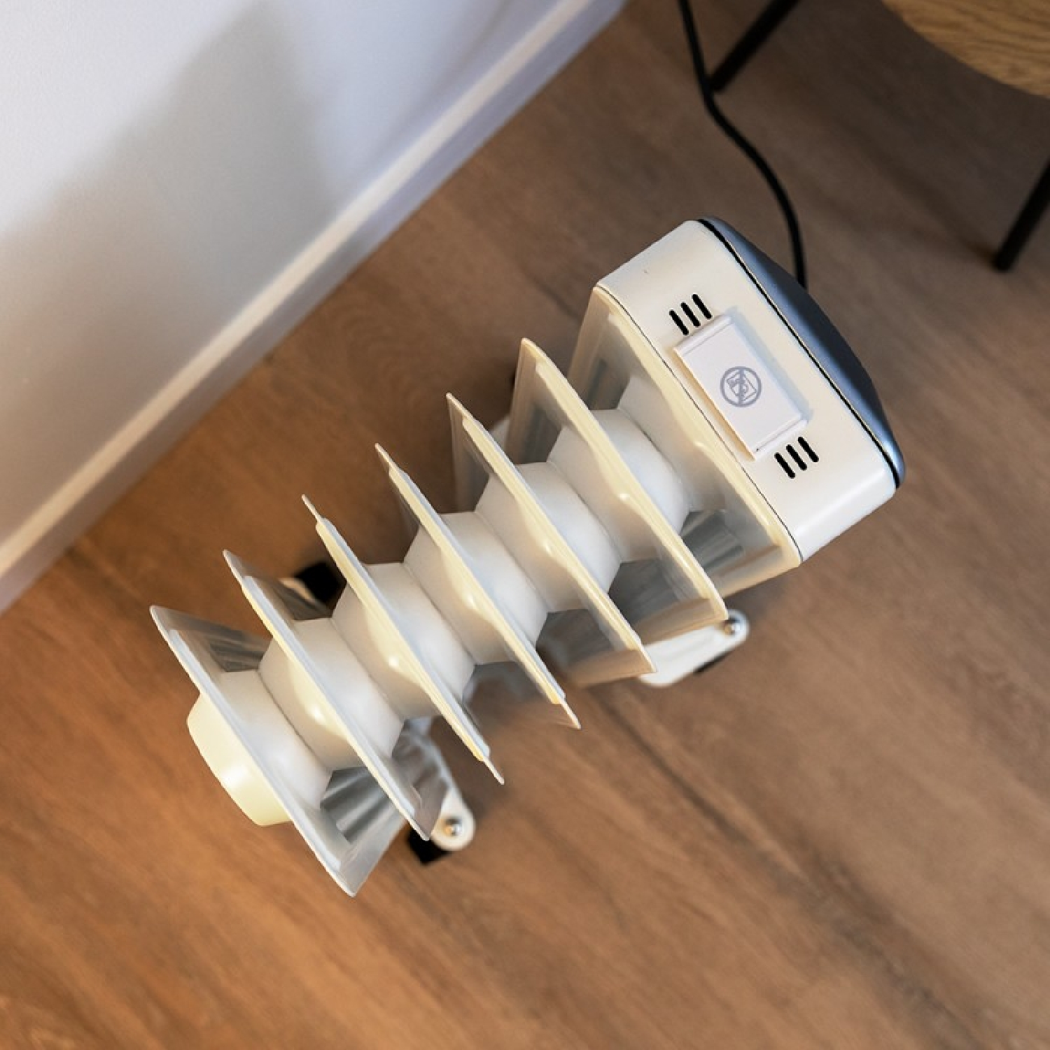 Olejowy grzejnik elektryczny na drewnianej podłodze.