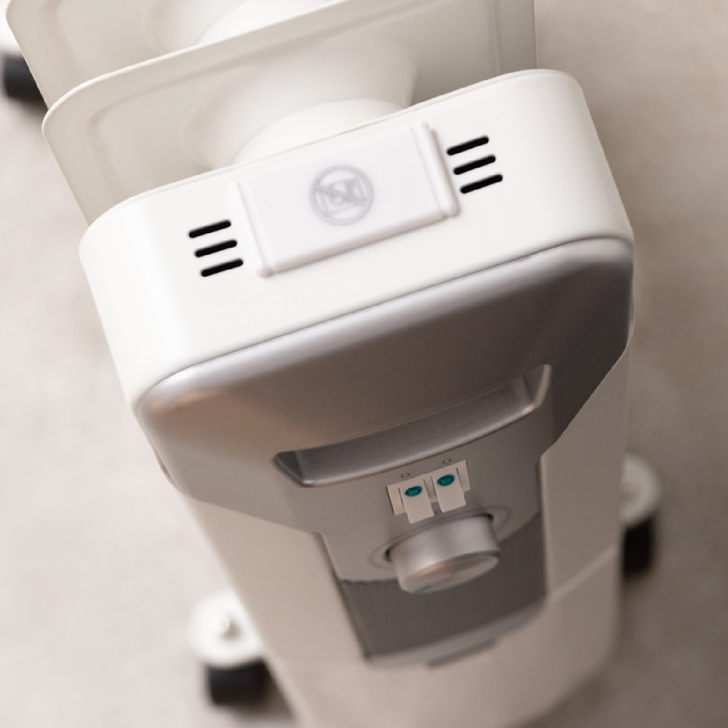 Białe i srebrne urządzenie, widok z góry, z otworami wentylacyjnymi i pokrętłem.