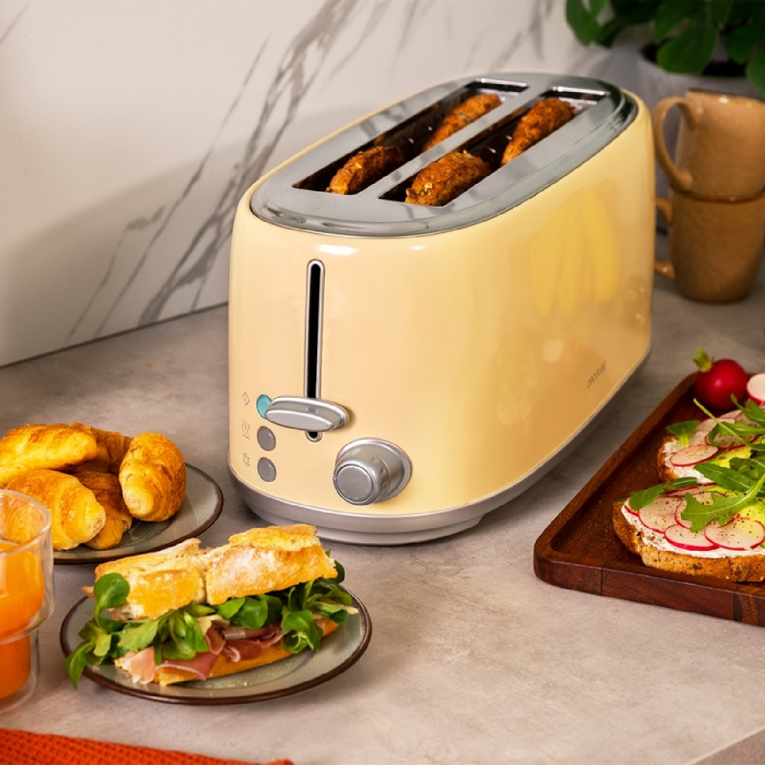 Gelber Toaster mit Toast und Brot auf der Theke. Croissants und Sandwiches sind vorhanden.