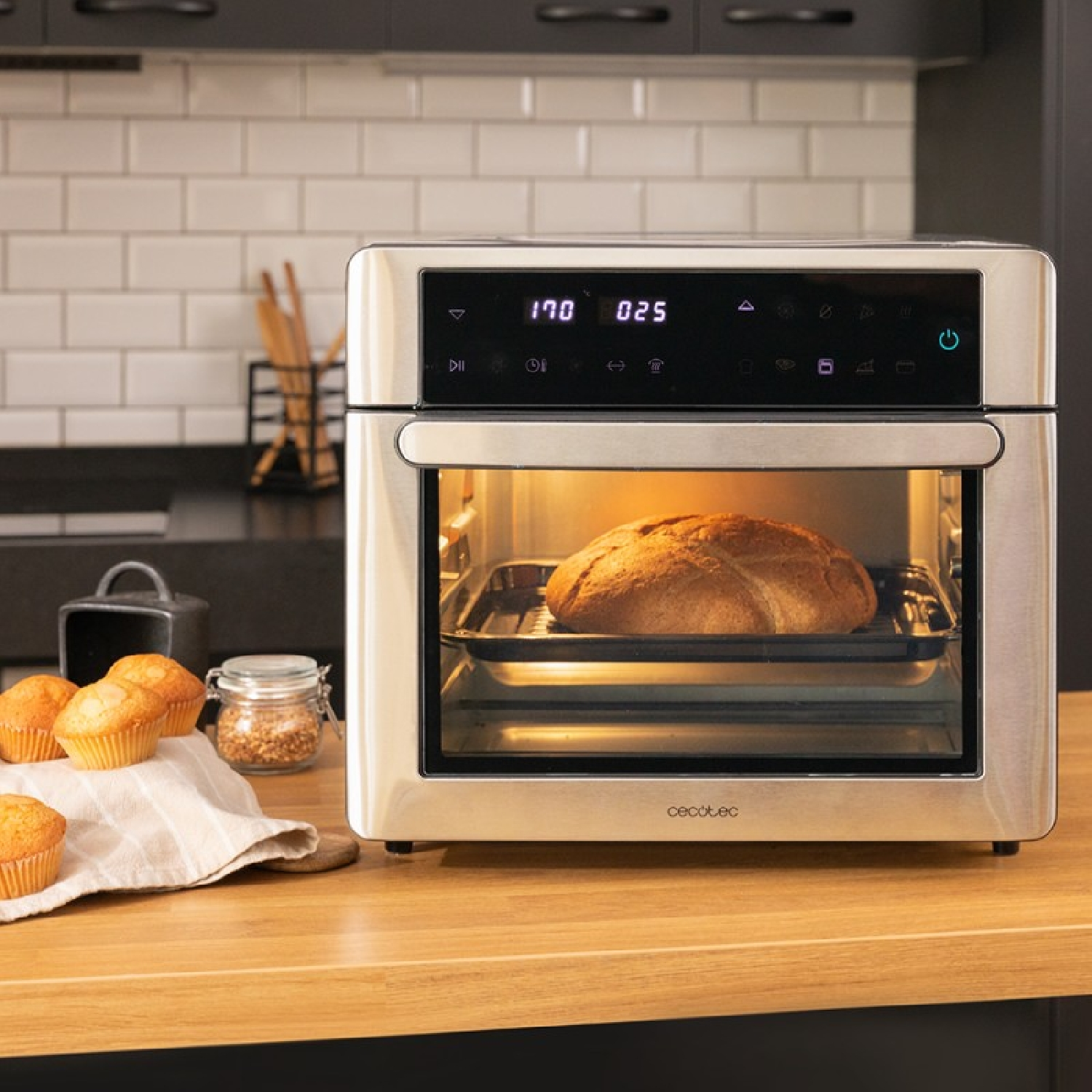 Una friggitrice ad aria con pane dentro e muffin sul tavolo.