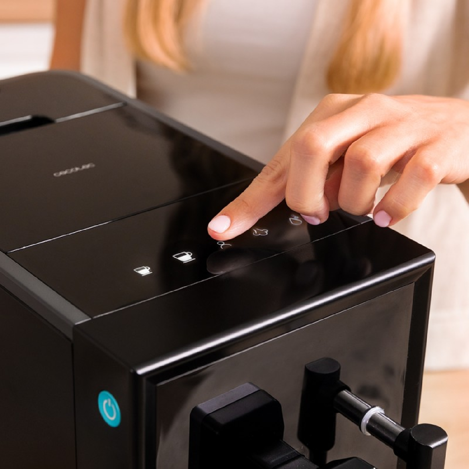 Mujer pulsando un botón en una cafetera. Máquina negra con botones.