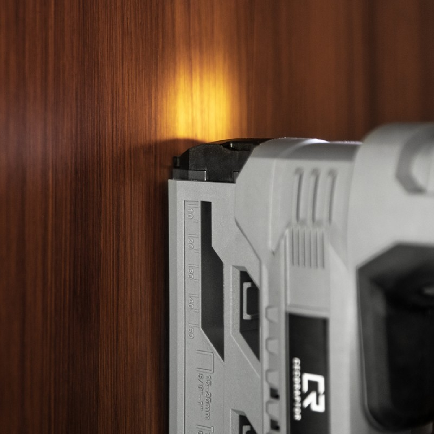 Close-up of a nail gun, highlighting the depth gauge and nail placement.