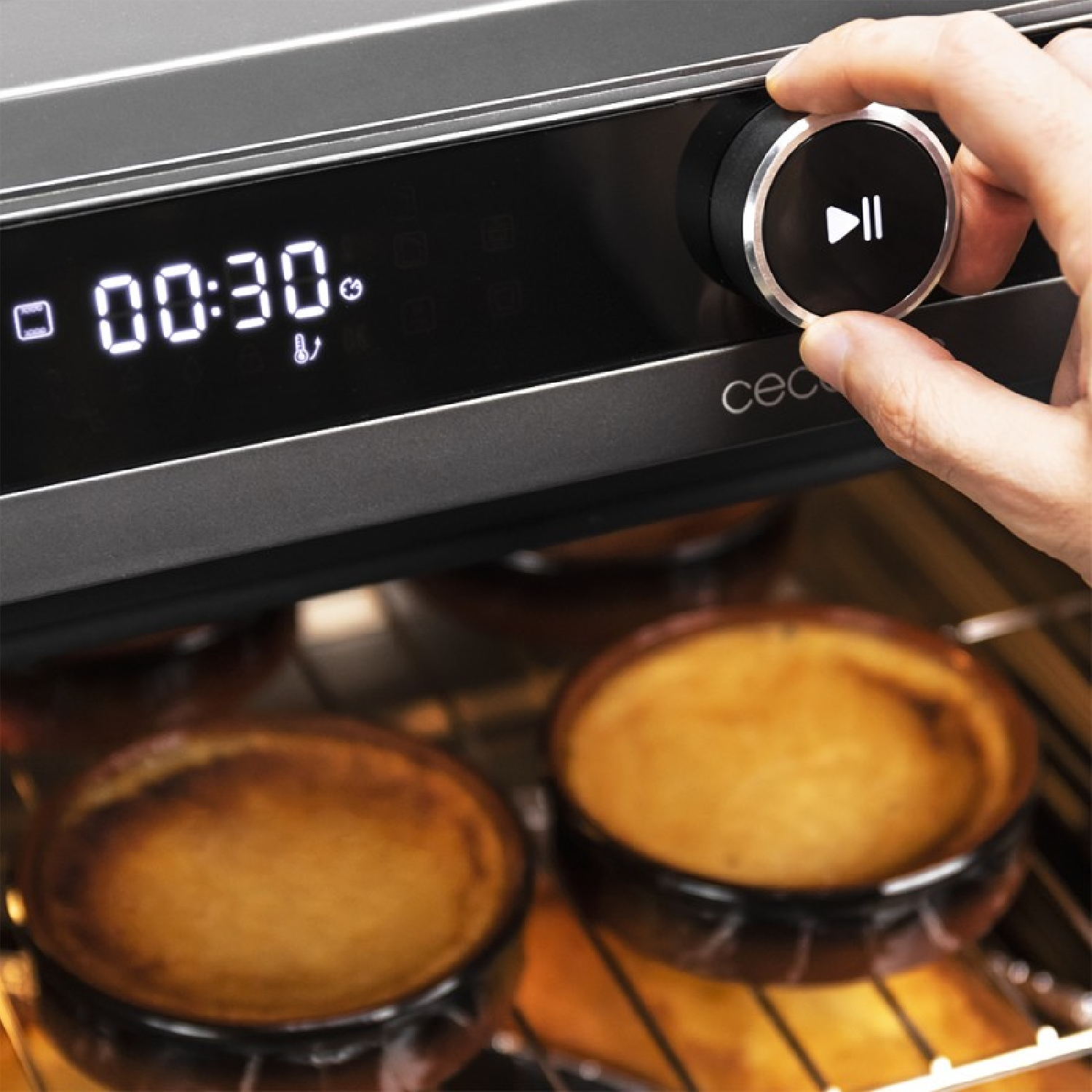 La mano de una persona gira un dial en un horno microondas.
