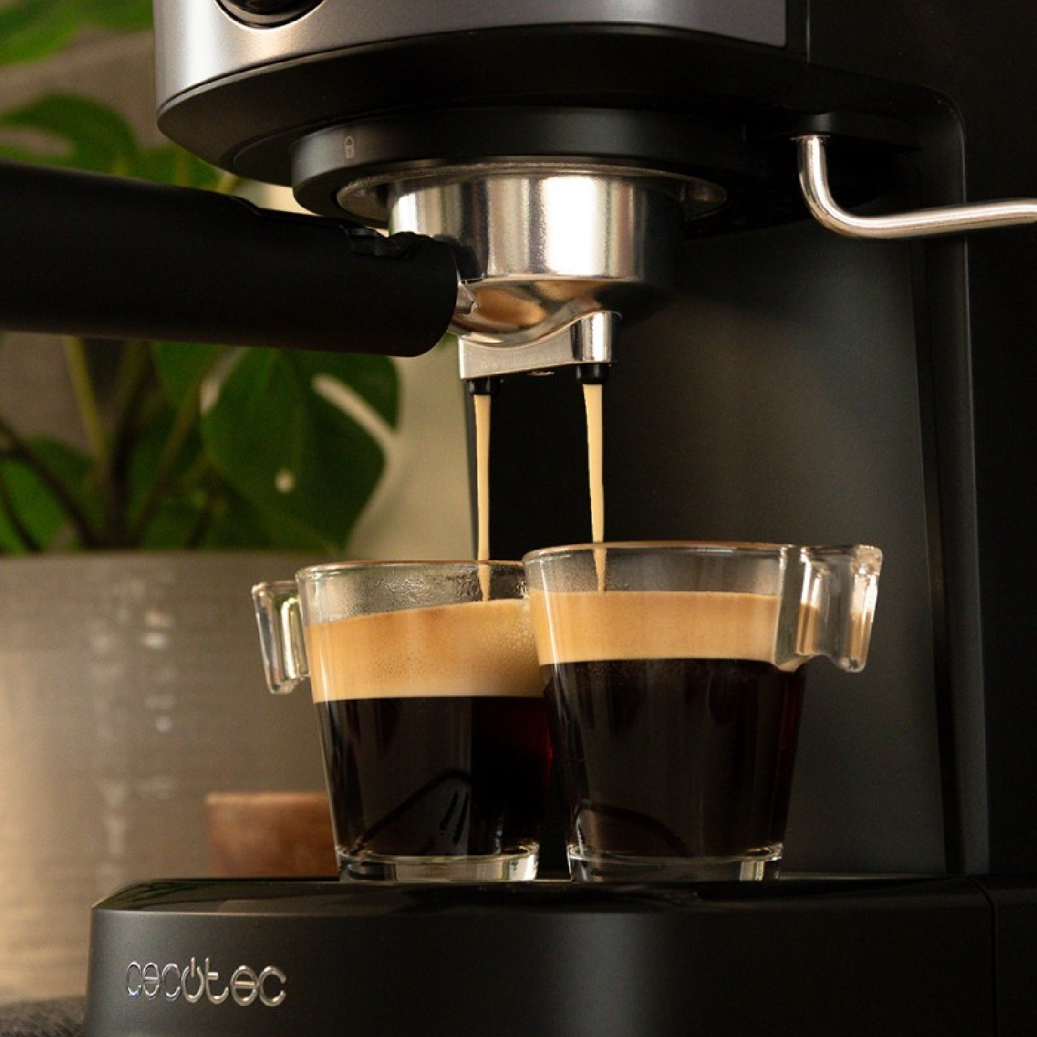 Primo piano di una macchina per espresso con due bicchieri che si riempiono di caffè. La macchina è nera e lo sfondo sfocato.