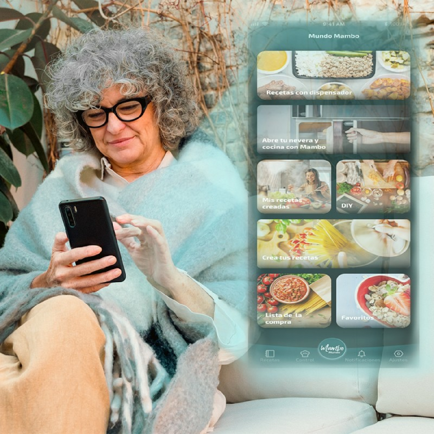 Una anciana sosteniendo un teléfono con una aplicación de cocina, sentada en un sofá bajo una manta.