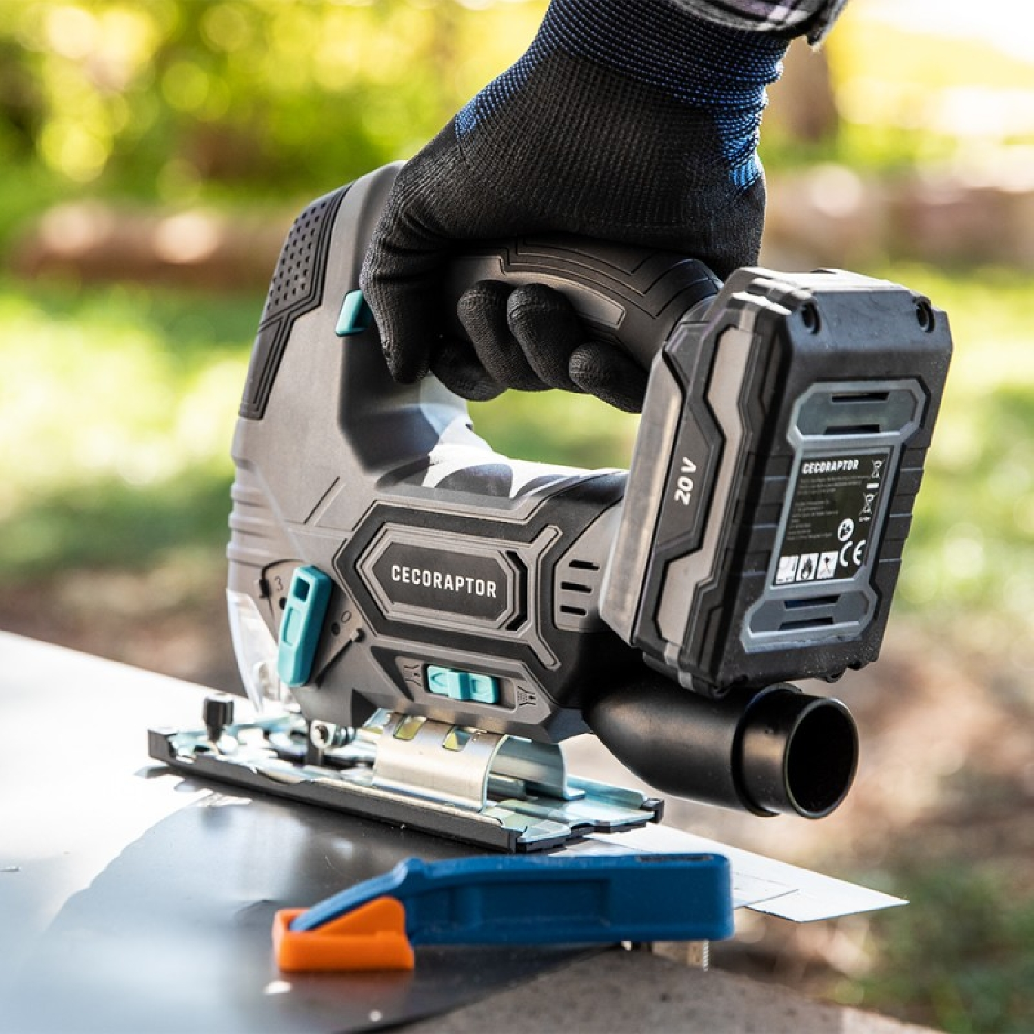 Osoba używająca wyrzynarki. Narzędzie i blacha w centrum uwagi.