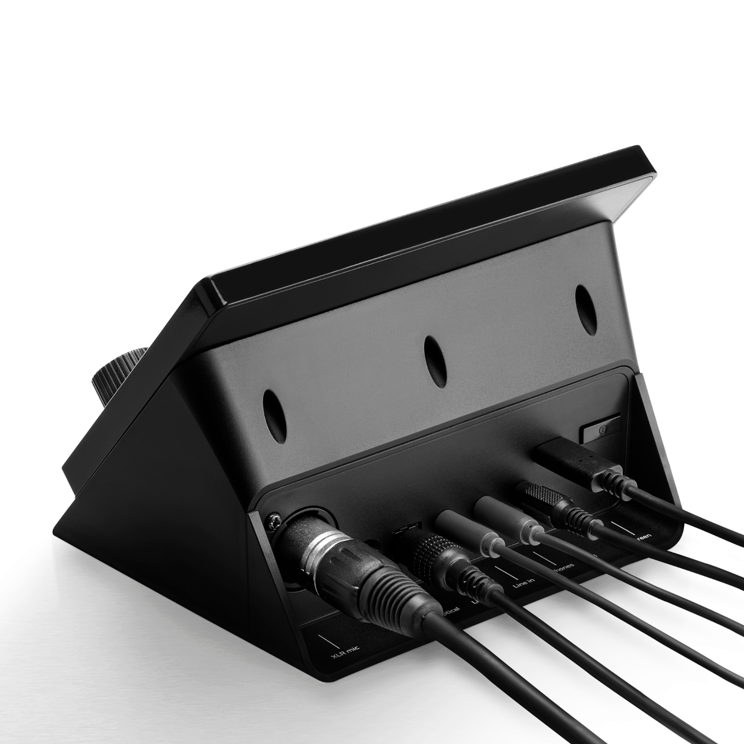 Zwarte audio-interface met meerdere poorten. XLR, USB en andere kabels aangesloten. Schuin zicht.