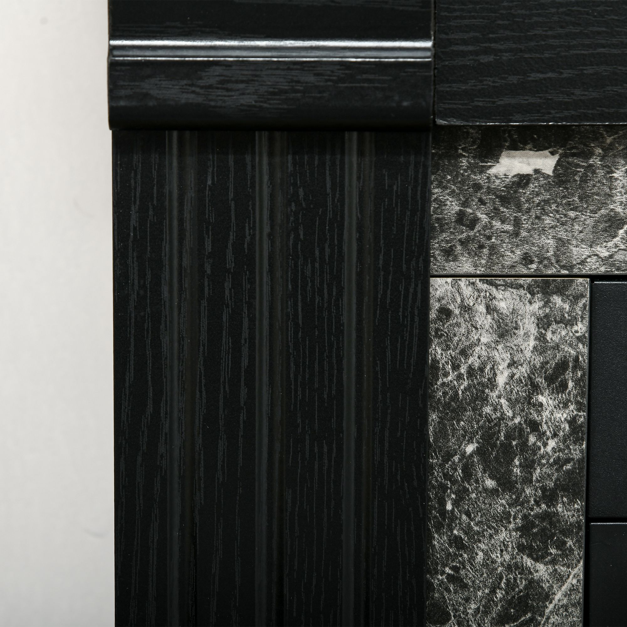 Un primo piano di un pannello di legno nero con motivi strutturati e simili al marmo.