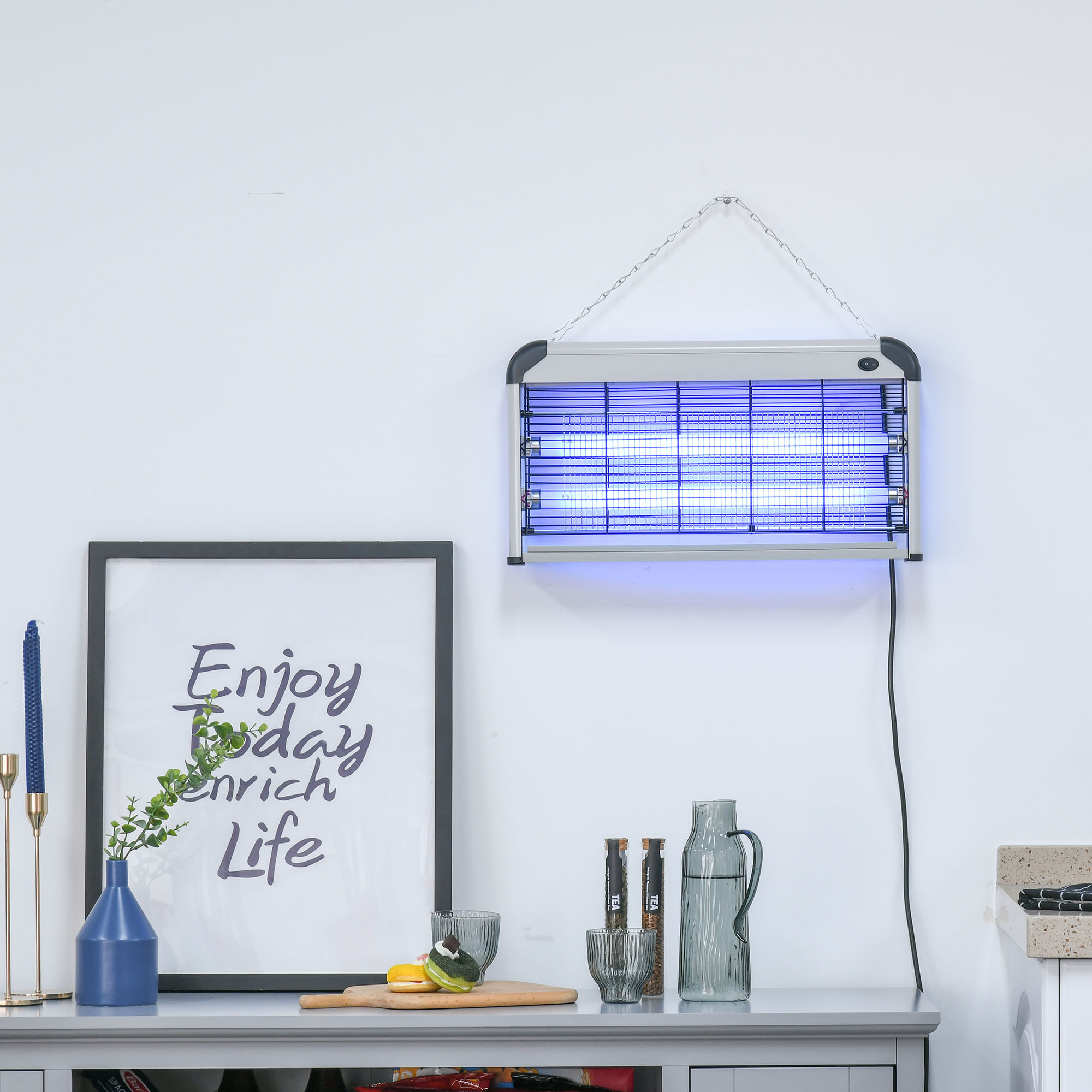 Un'uccisore di insetti sospeso con luce blu e oggetti decorativi su un tavolo.