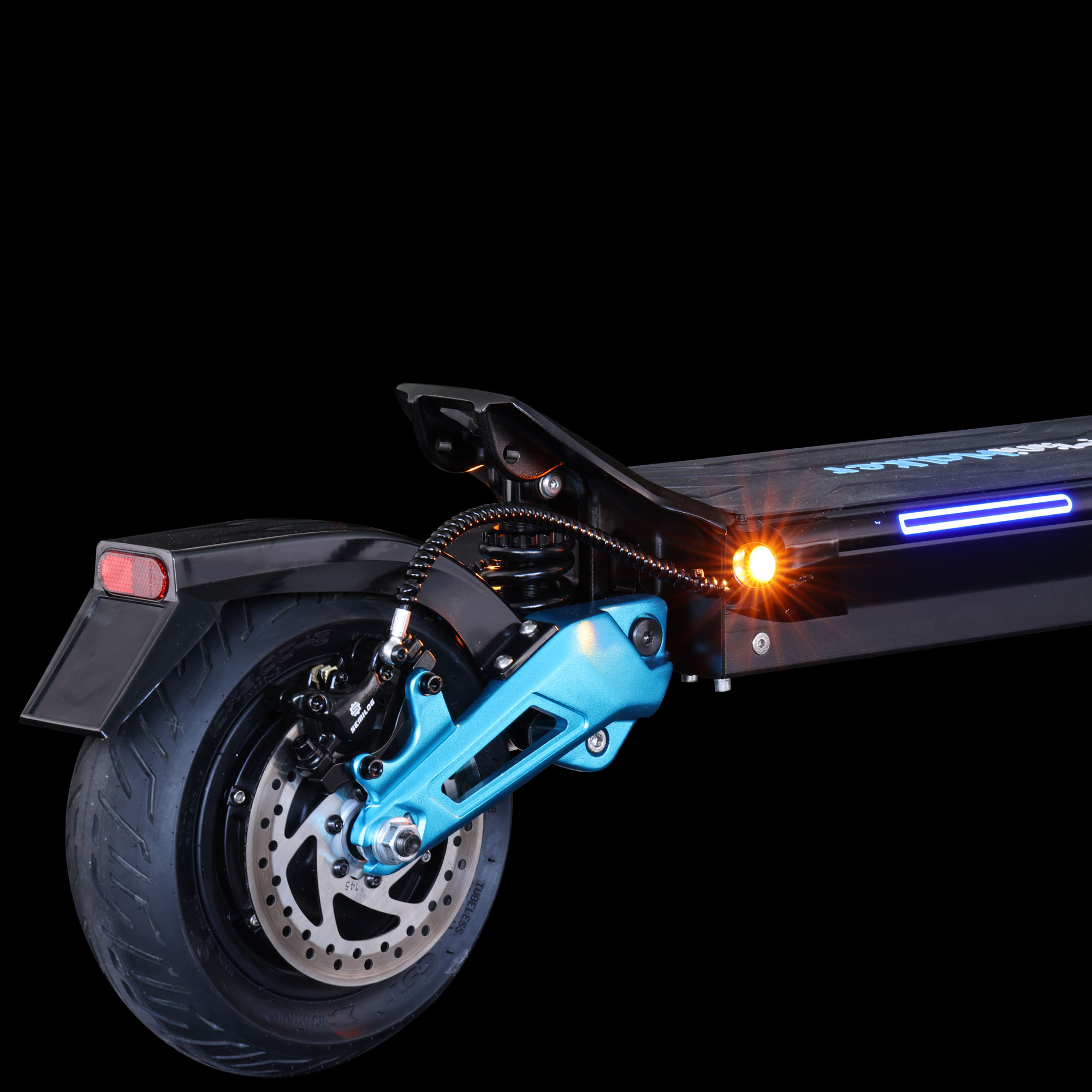 Ein Hinterrad eines E-Scooters mit blauer Federung, orangem Licht und schwarzem Hintergrund.