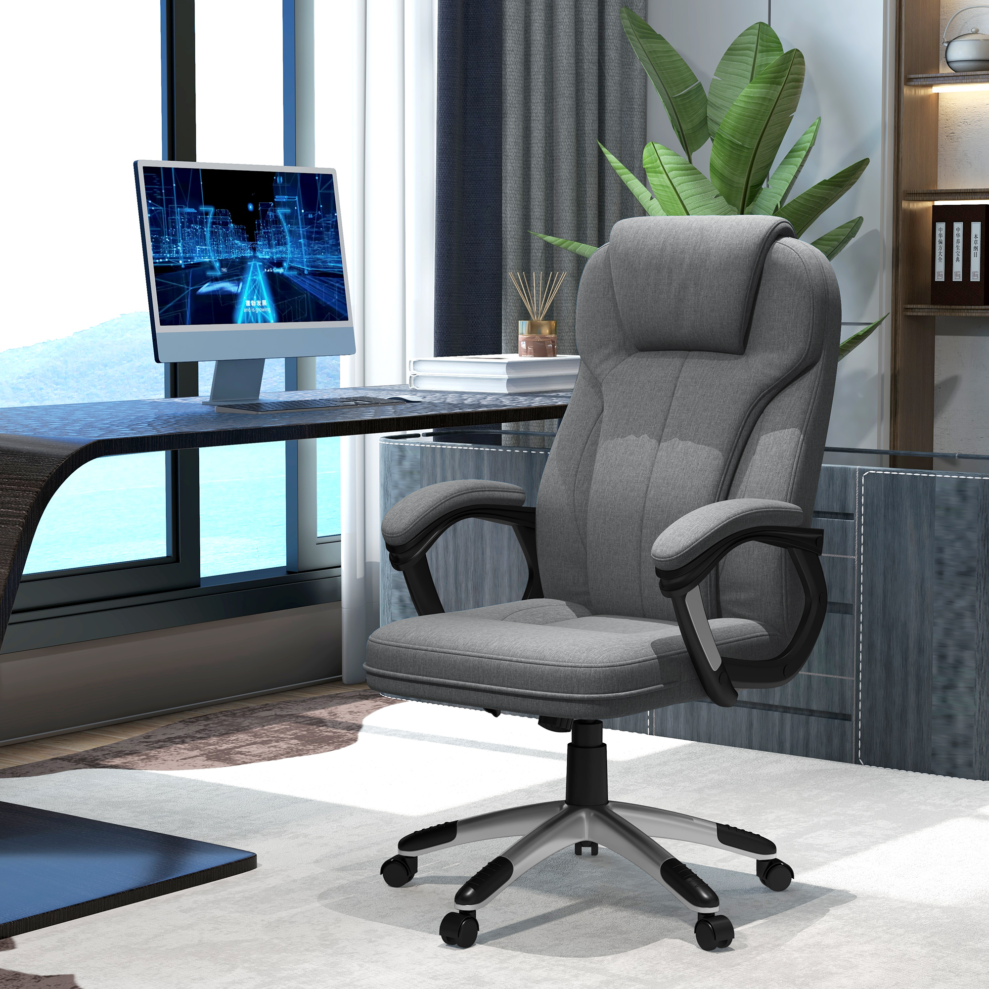 Una silla de oficina gris con ordenador, escritorio y planta al fondo.