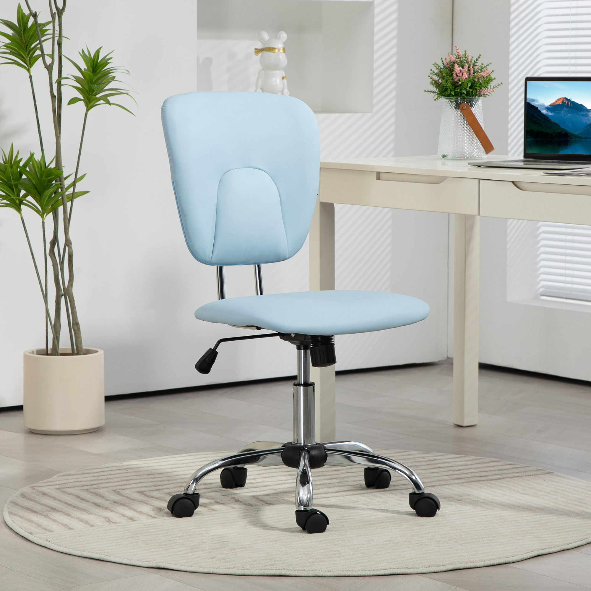 Silla de oficina azul claro con pared blanca, escritorio con portátil y una planta.