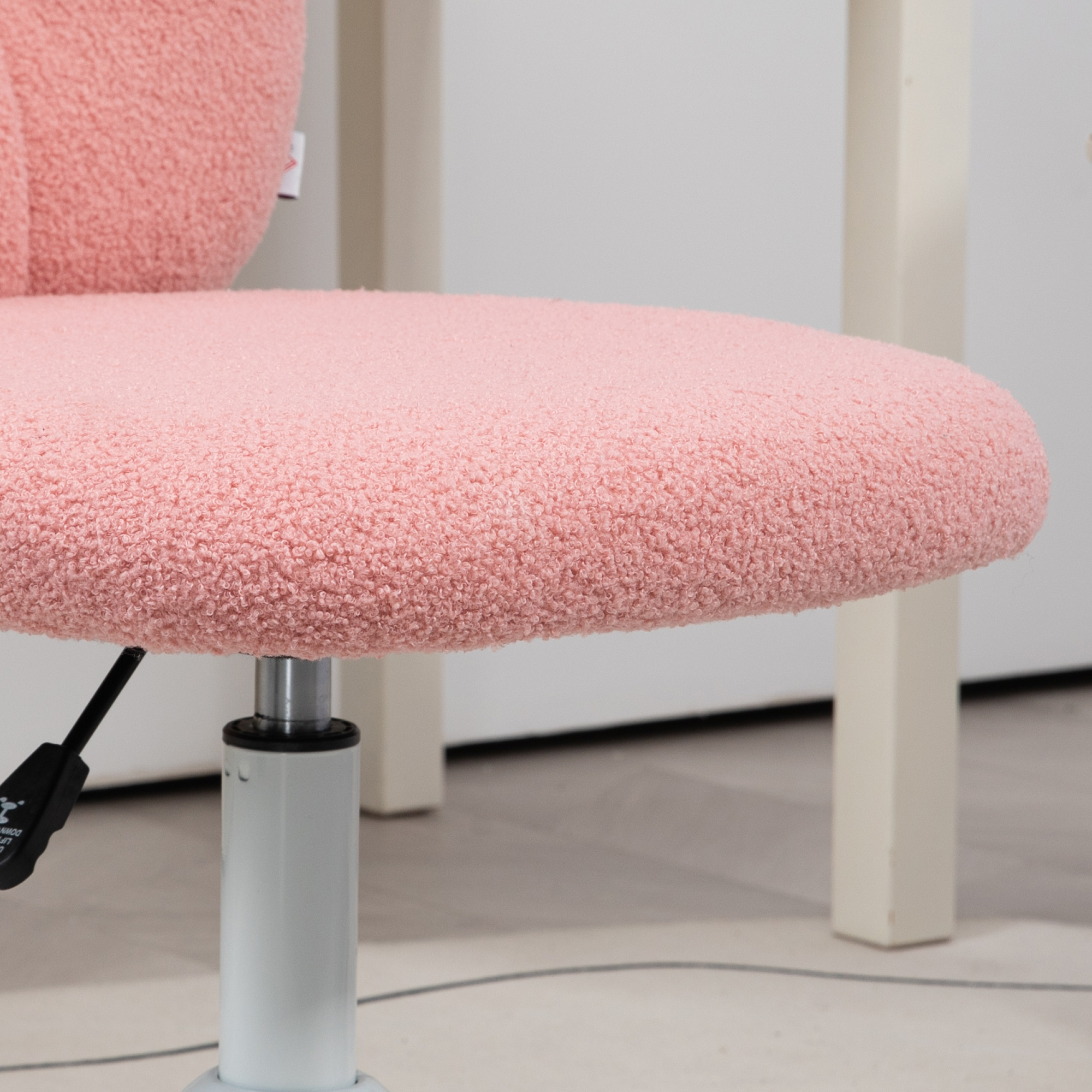 Primer plano de una silla de oficina rosa y esponjosa. Pata blanca y palanca.