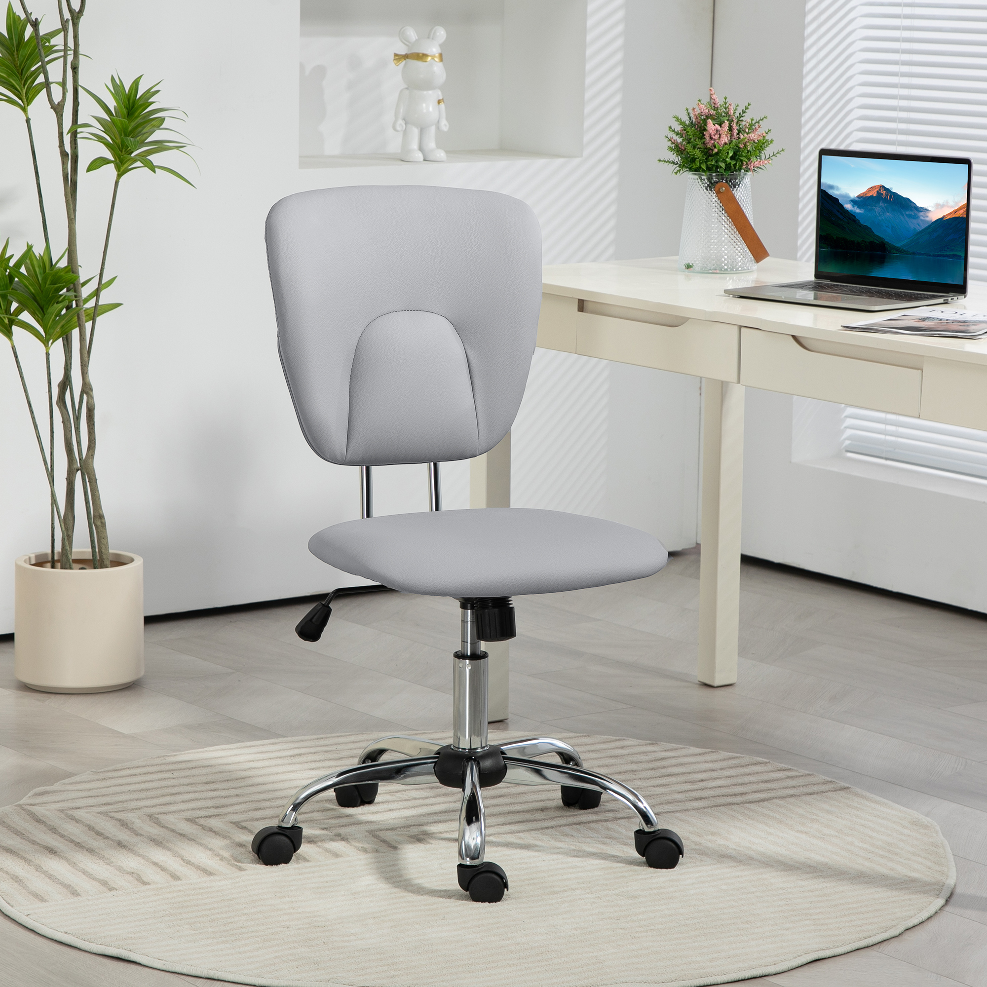 Una silla de oficina gris con ruedas frente a un escritorio.