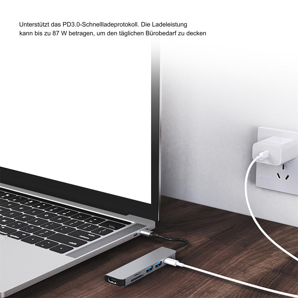 Ein Laptop, der mit einem Hub verbunden ist, mit einem Netzteil, das in eine Wand gesteckt wird.