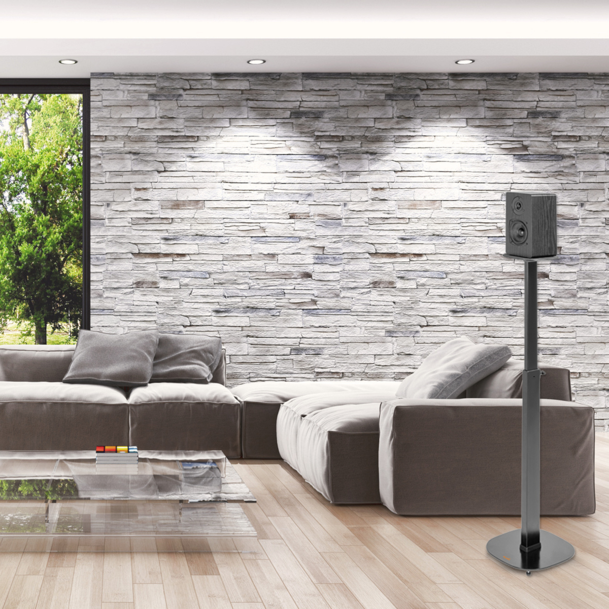 Modernes Wohnzimmer mit grauem Sofa, Steinwand und Lautsprecher auf einem Ständer.