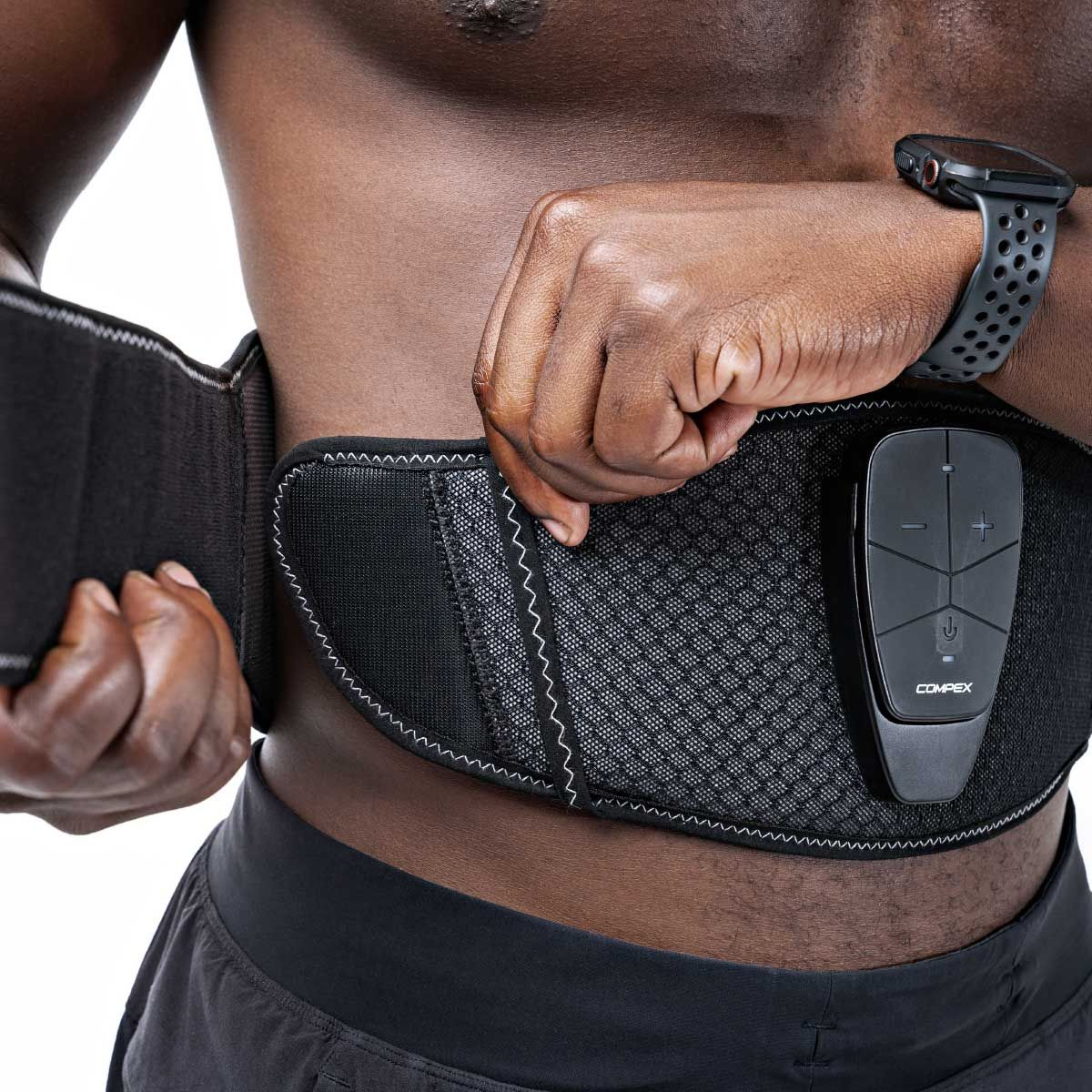 Ein Mann trägt ein schwarzes Gürtelgerät um den Oberkörper mit Fernbedienung.