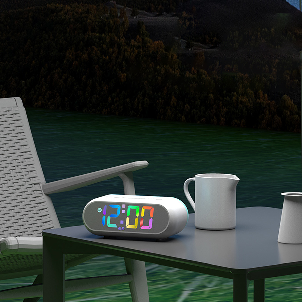 Eine Digitaluhr auf einem Tisch zeigt 12:00 Uhr. Eine weiße Tasse und eine Vase daneben, draußen.