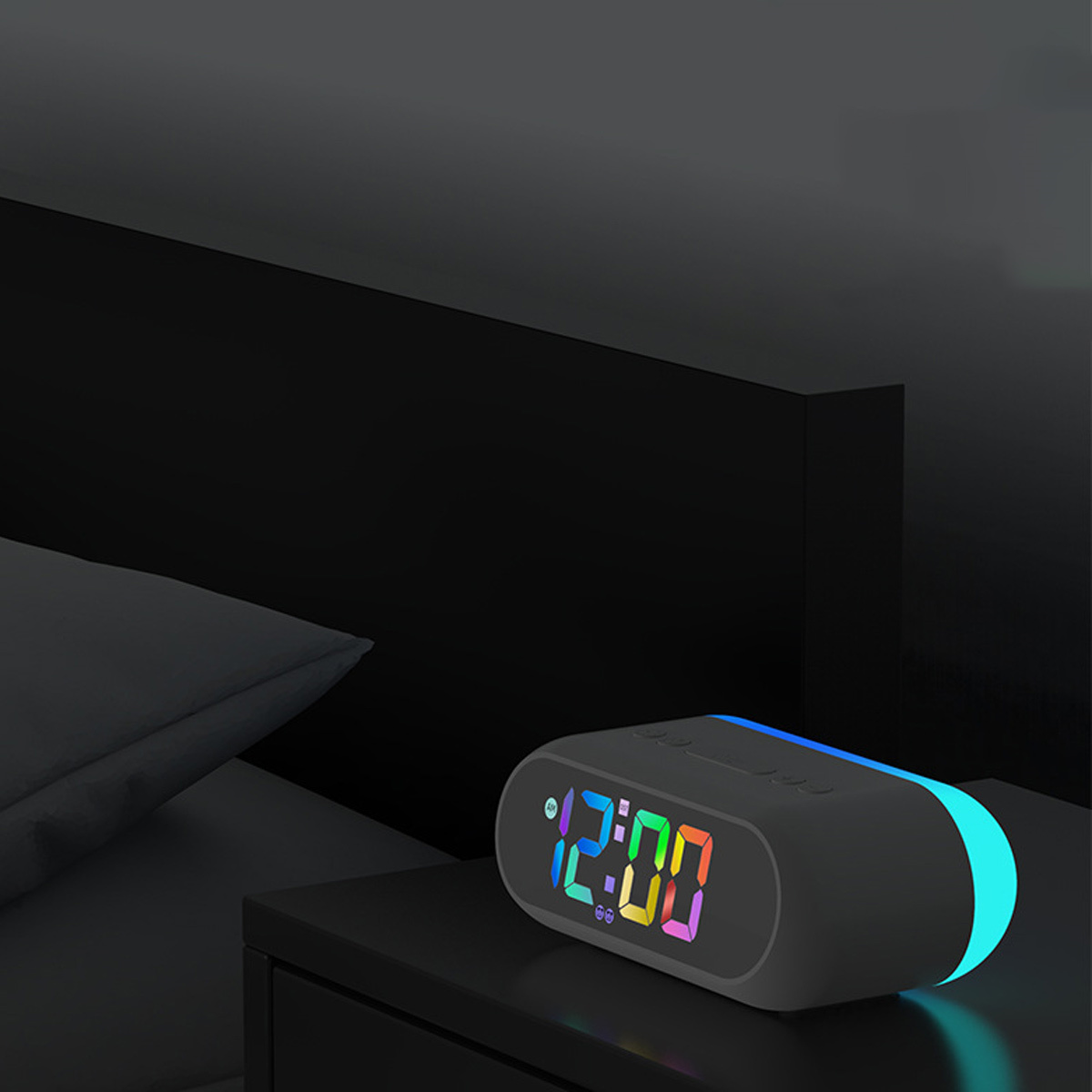 Ein grauer Wecker auf einem Nachttisch. Die Uhr zeigt eine farbenfrohe Zeit an. Der Hintergrund ist ein dunkles Zimmer.