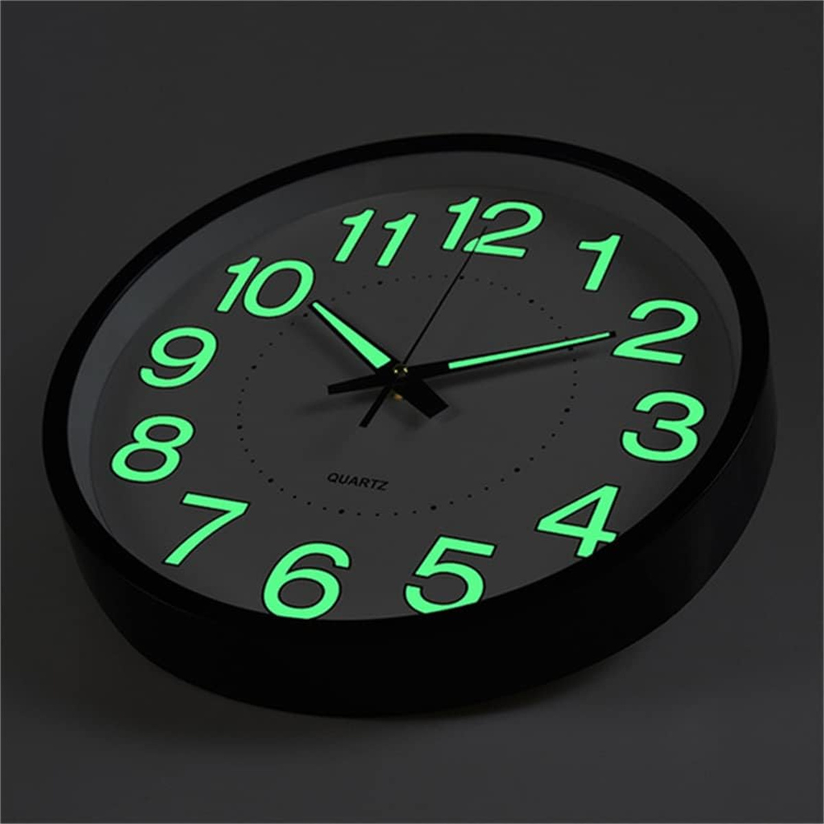Schwarz gerahmte Uhr mit leuchtend grünen Zahlen und Zeigern auf dunklem Hintergrund.