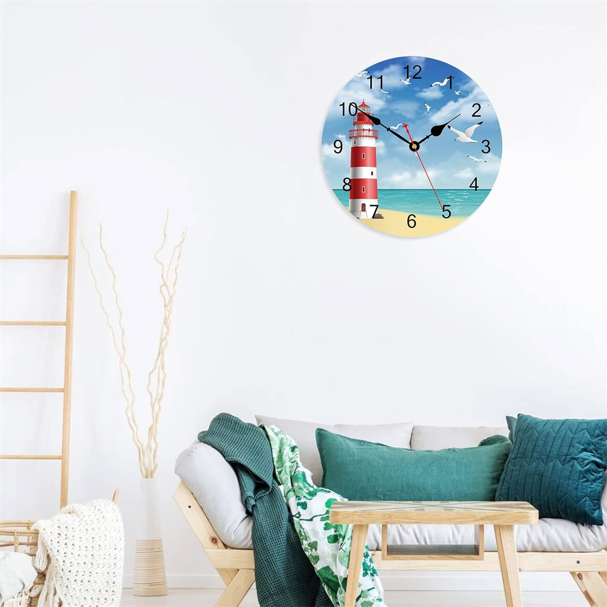 Eine Uhr an einer Wand mit Leuchtturm, Möwen und blauem Himmel. Ein Sofa und eine Holzleiter sind im Bild.
