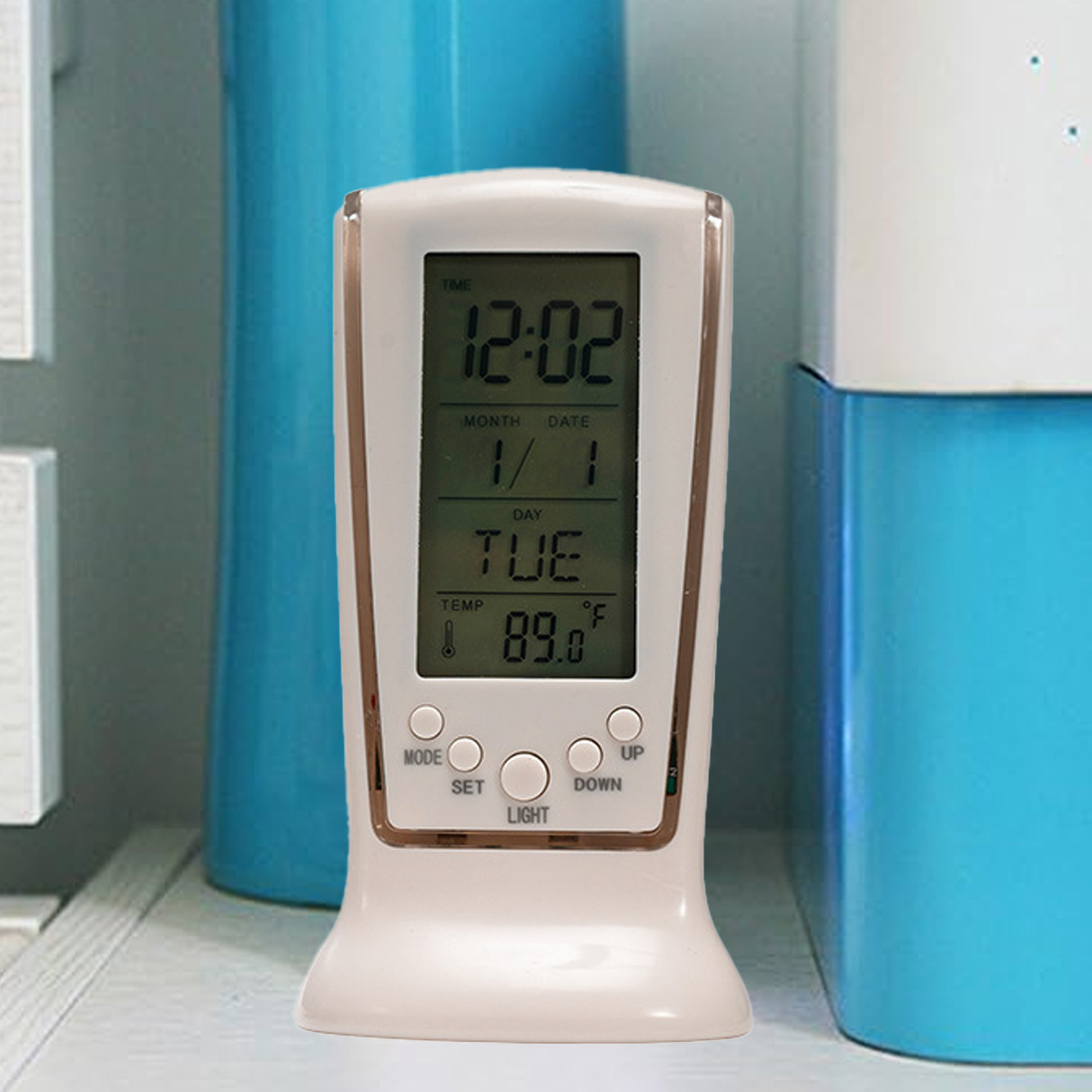 Weiße Digitaluhr. Sie zeigt Zeit, Datum und Temperatur in einer gut beleuchteten Umgebung an.