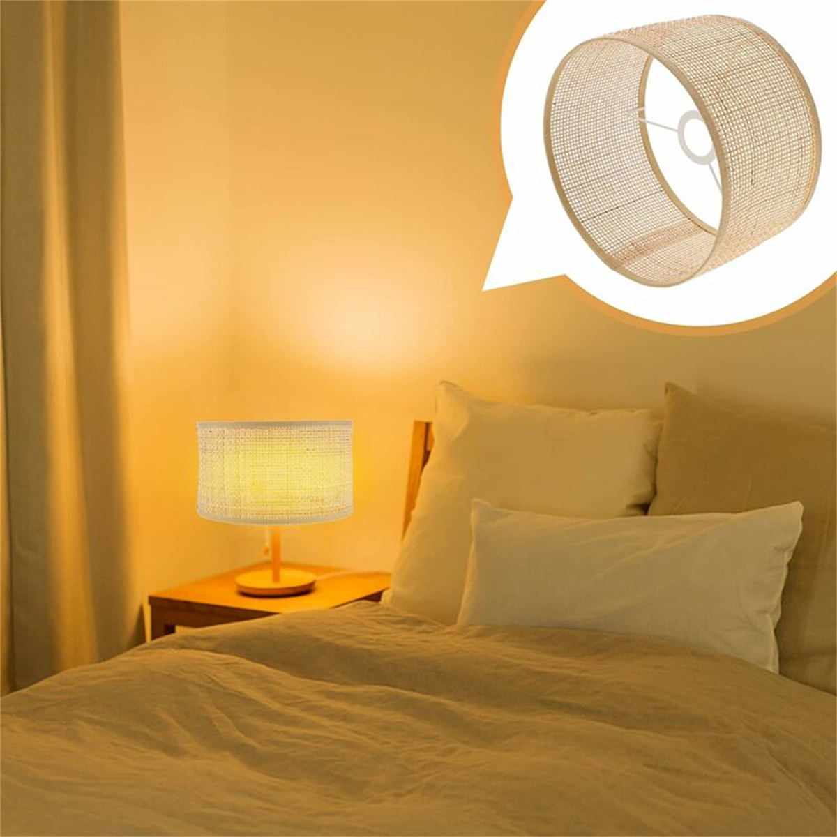 Eine kleine Lampe mit beigem Schirm steht auf einem Nachttisch. Im Hintergrund befindet sich ein Bett.