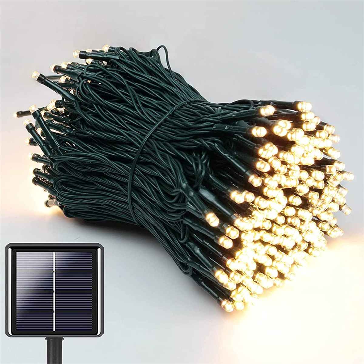 Ein Bündel grüner Lichterketten mit kleinen weißen Lichtern. Ein Solarpanel befindet sich in der Ecke.