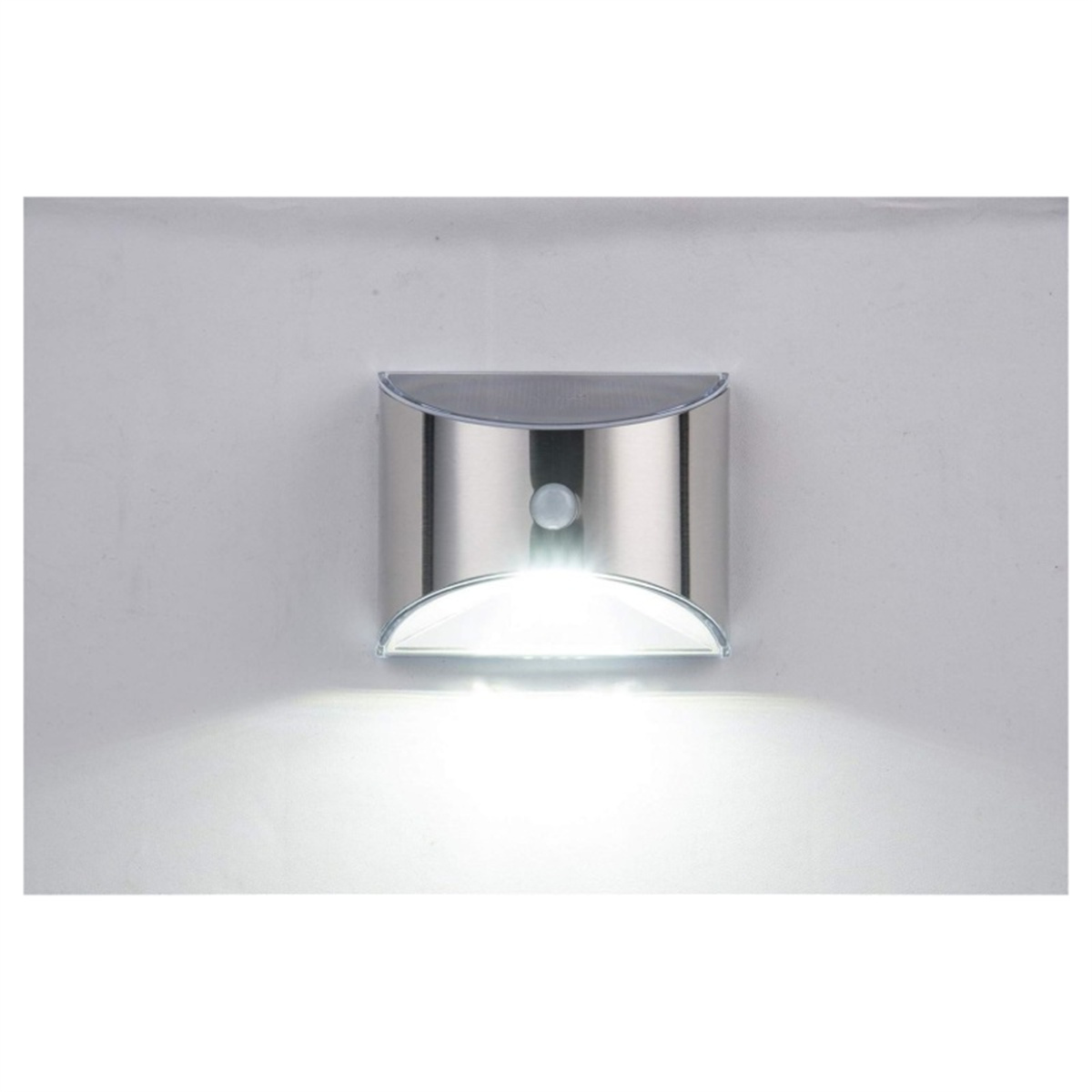 Silberne Außenleuchte an weißer Wand, emittiert Licht.