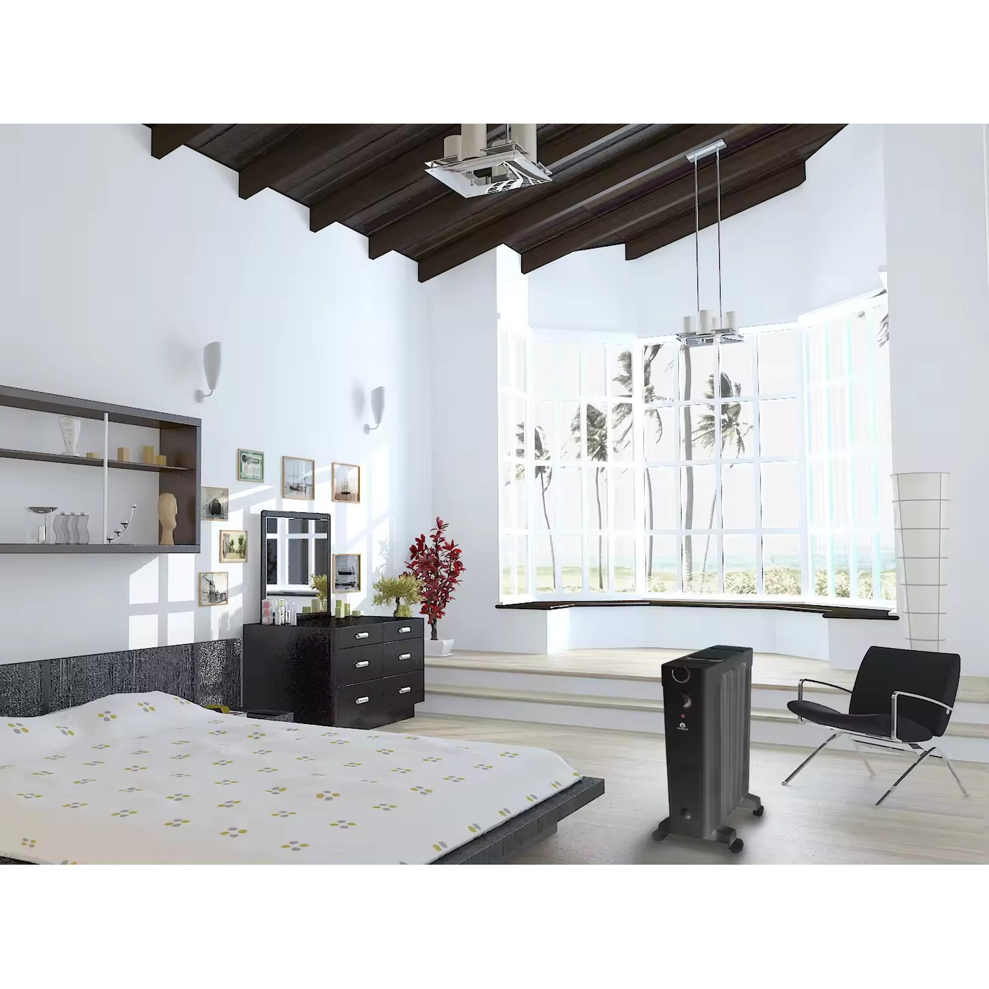 Un dormitorio con una cama, un radiador y una silla. Una gran ventana muestra una vista del cielo.