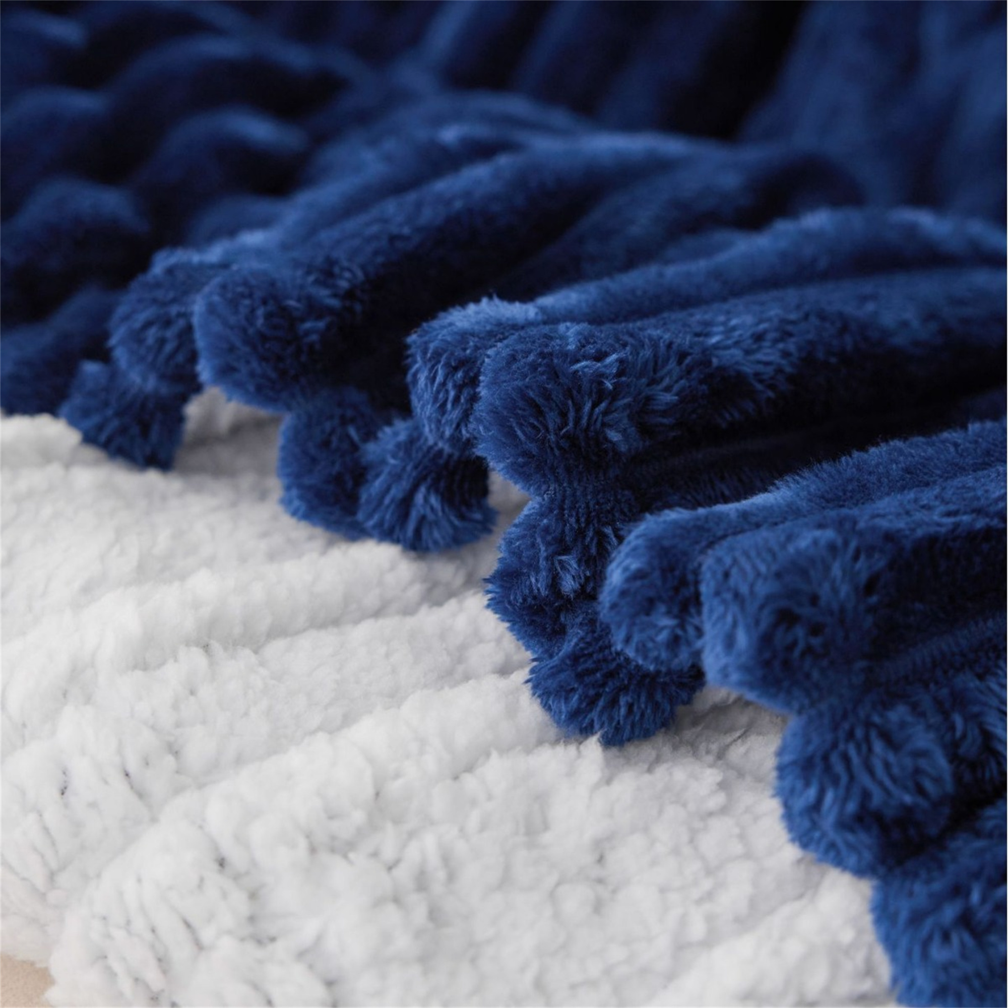 Nahaufnahme einer blau-weißen Plüschdecke mit strukturierter, flauschiger Optik.