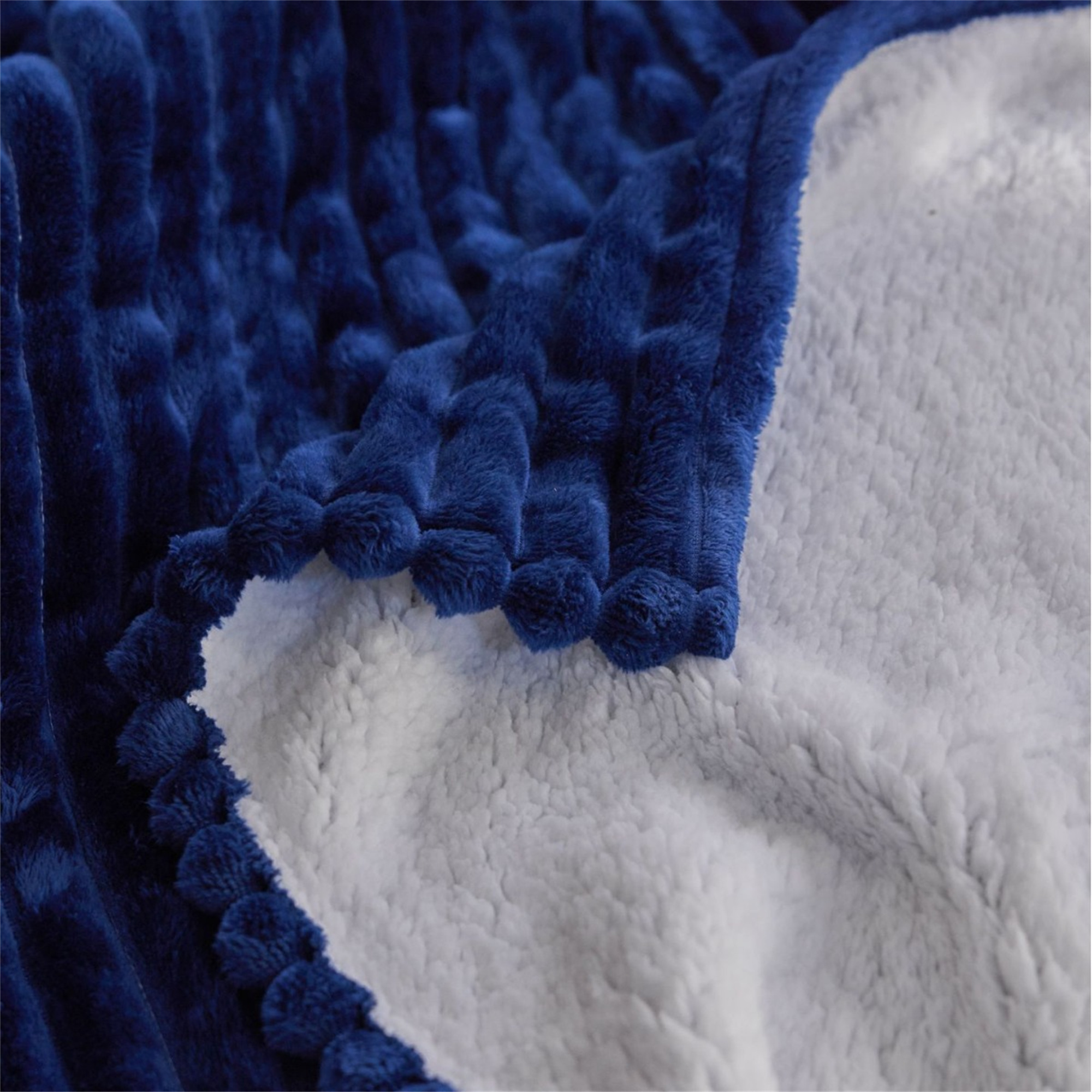 Eine blaue und weiße, flauschige Decke zeigt eine Nahaufnahme der Textur.